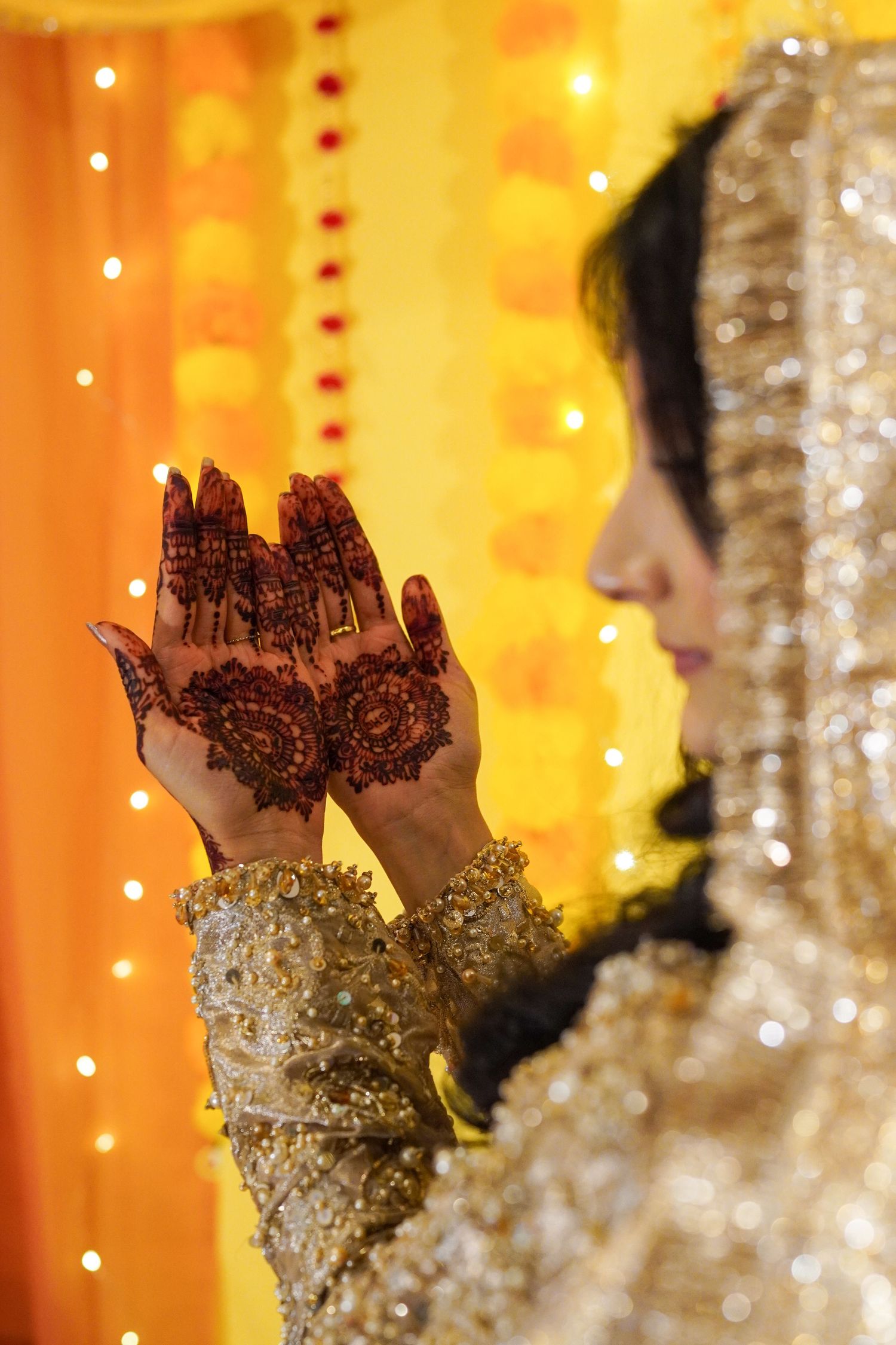 Close-up shots of intricate henna designs on hands with glowing golden lights in the background.