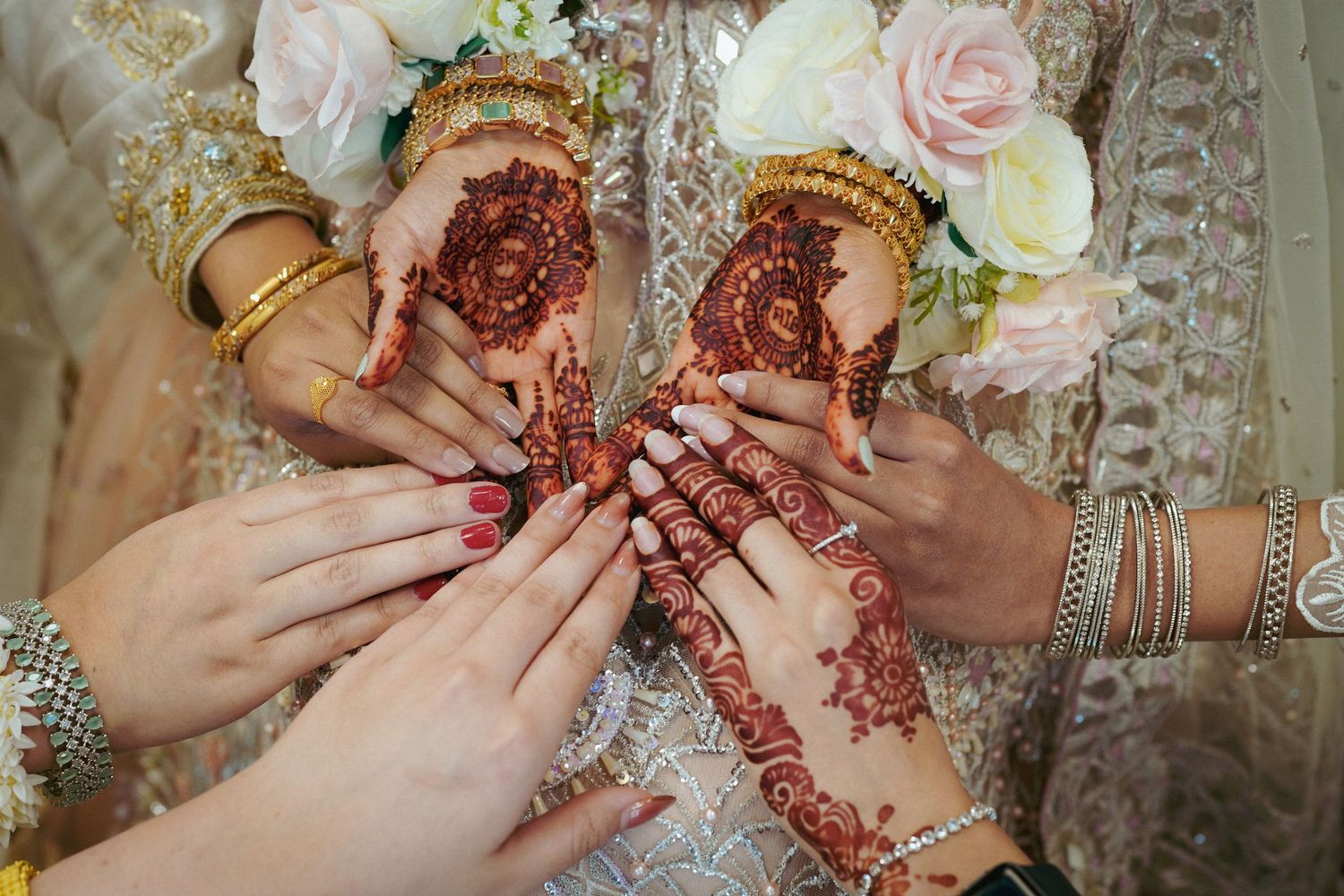 Close-up shots of hands adorned with intricate henna designs and jewelry.