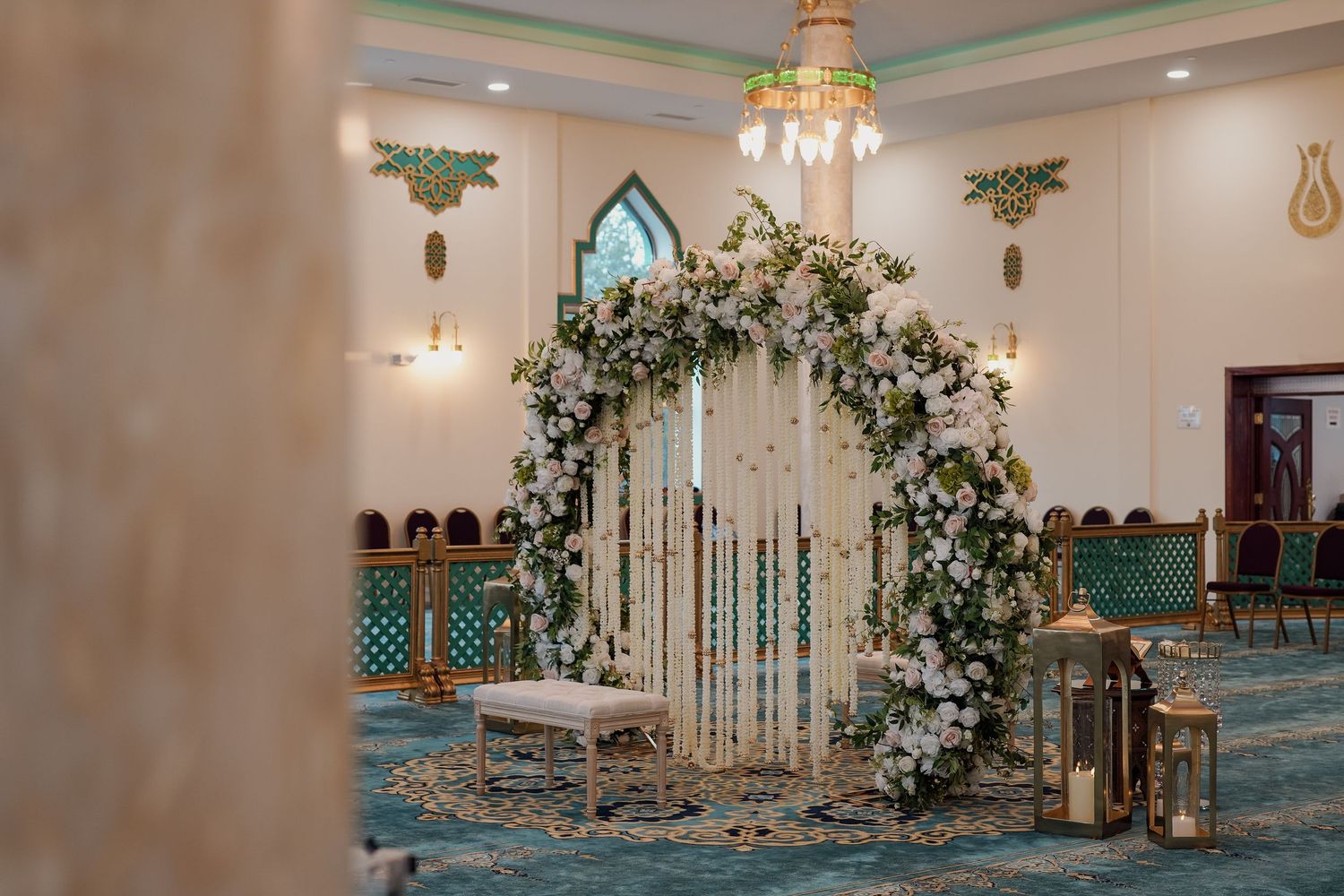 photography of elegant wedding venue interior with white floral arrangements and crystal chandeliers creating a romantic atmosphere.