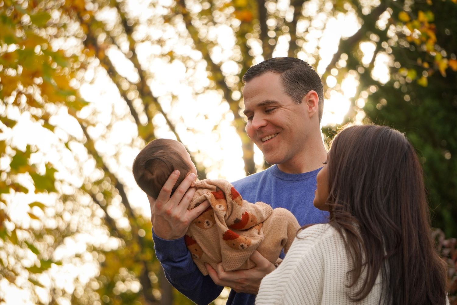 Golden hour outdoor portrait of a family sharing a loving moment together.