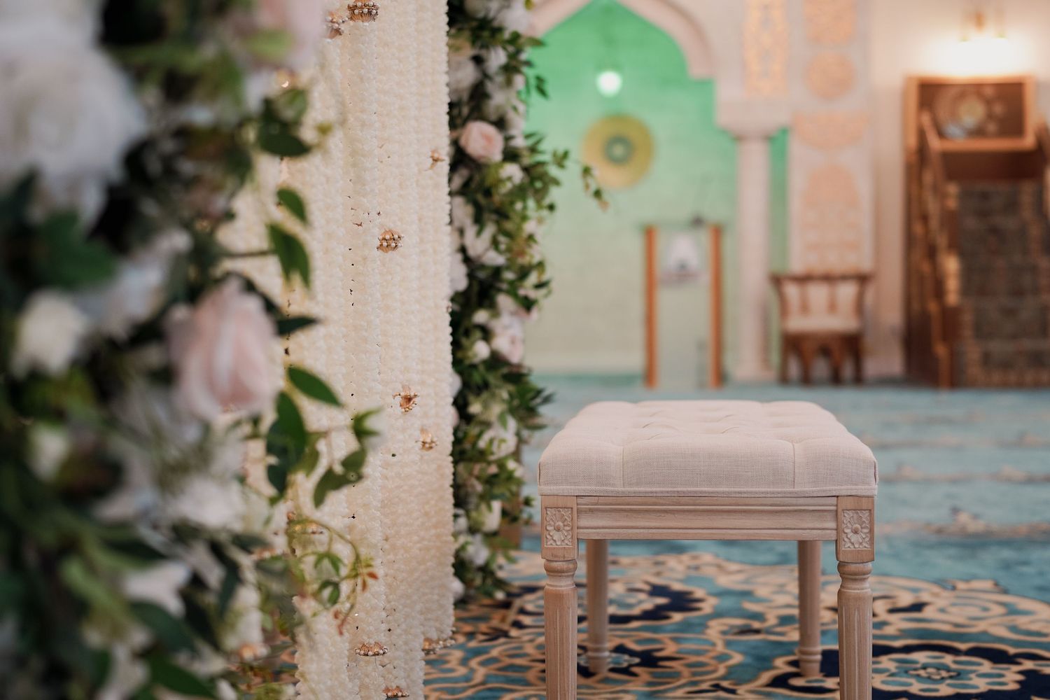 Elegant wedding ceremony setup with white floral arrangements and decorative chairs.