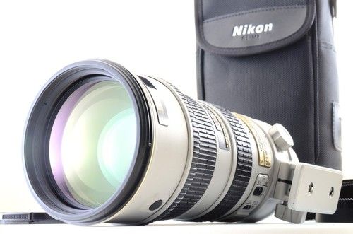 Nikon telephoto zoom lens with large front element and tripod collar, stored in a Nikon carrying case.