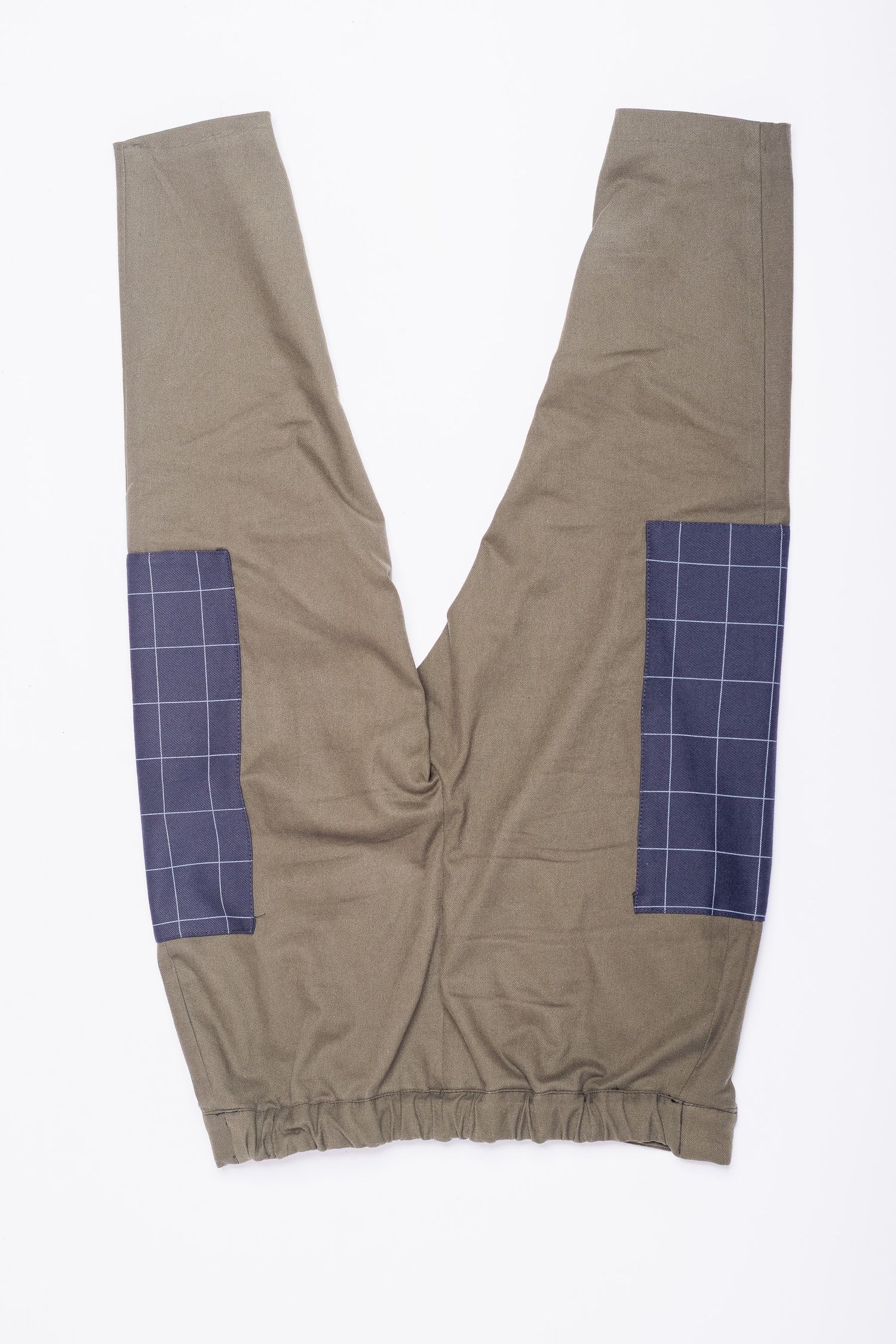 Olive green pants with navy blue checkered patch pockets laid flat on white background.