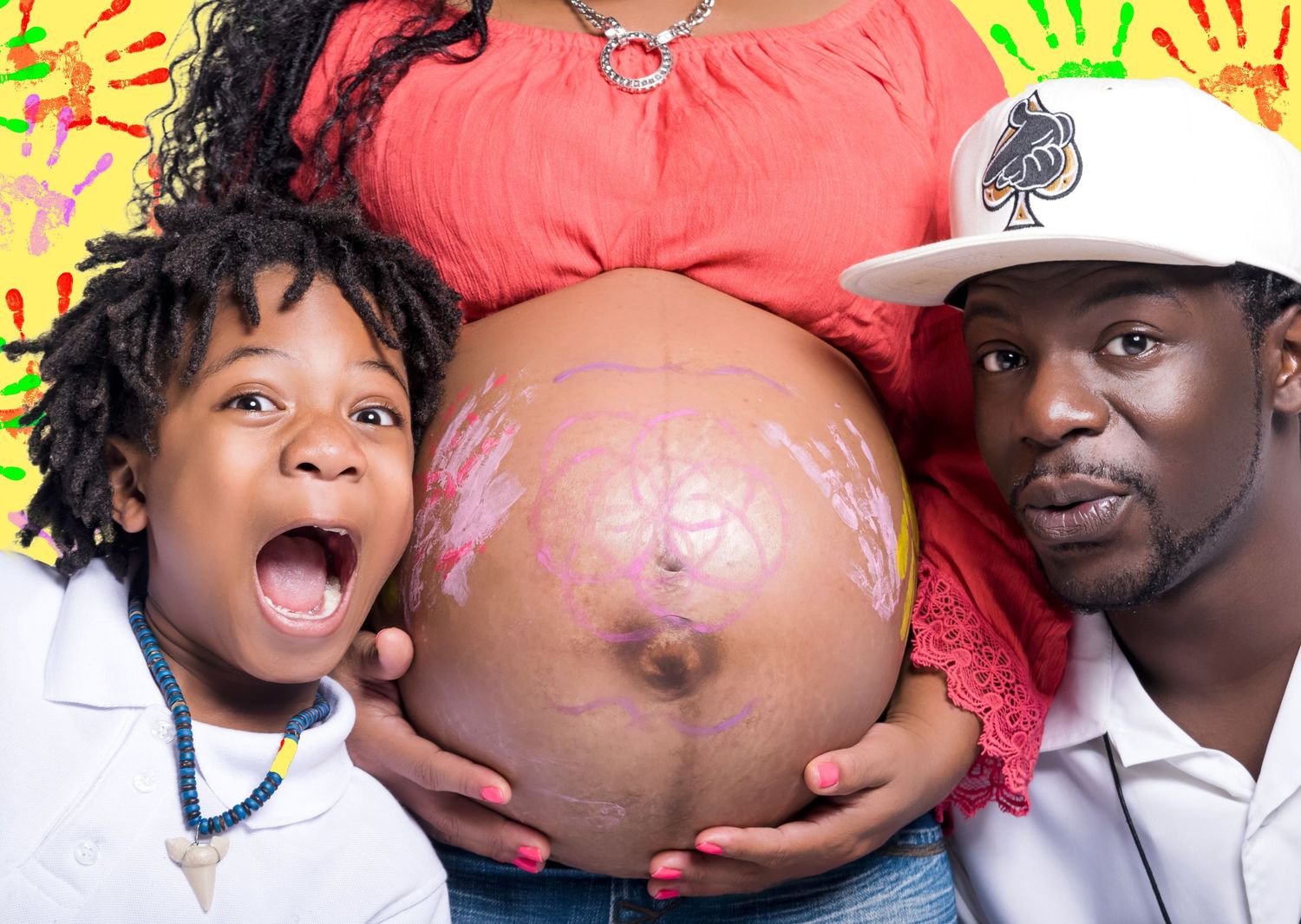 Fun maternity photo of couple and child showing off painted pregnant belly.