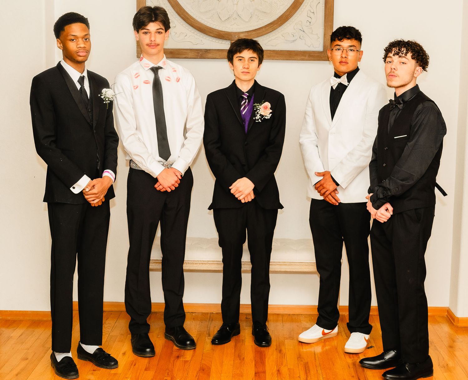 Five young men in formal suits posing for prom photo.