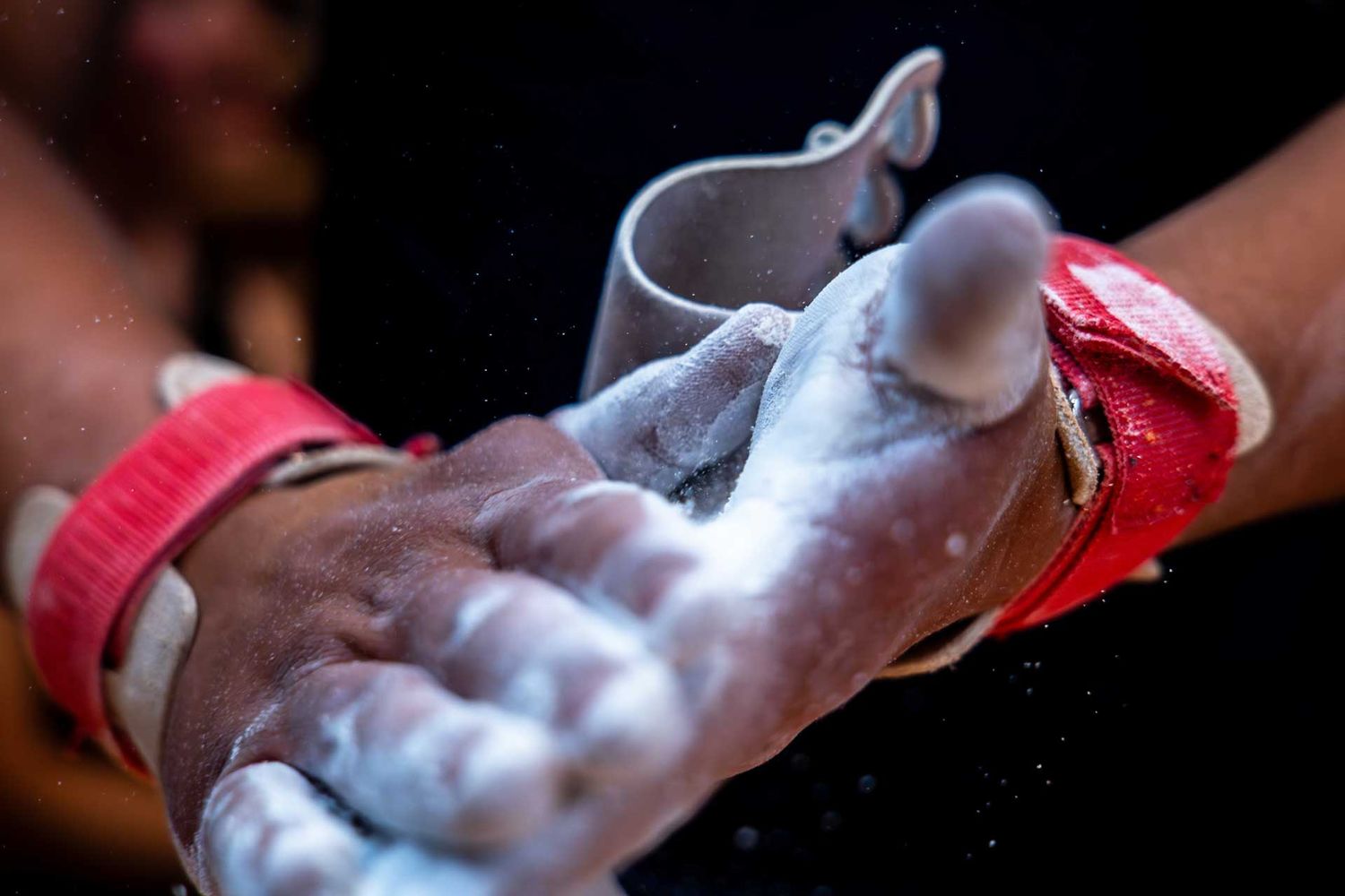 Sportfotografie: Turner reibt seine Hände mit Magnesium für das Ringturnen ein