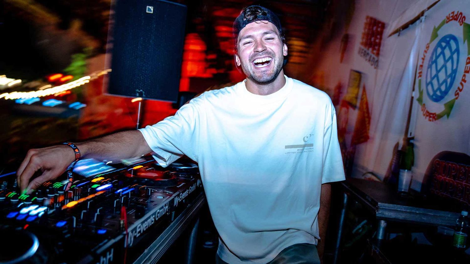 Eventfotografie: DJ Giannex lacht glücklich in die Kamera während seines Auftrittes während seinem Auftritt am Gurtenfestival