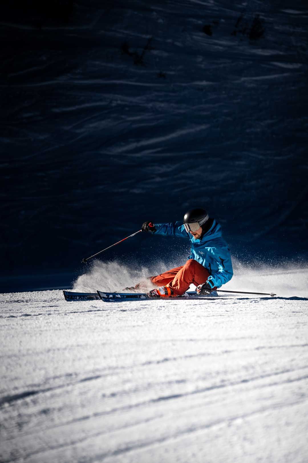 Sportlifestylefotografie: Skifahrer curved auf einer Piste – schönes Lichtschattenspiel