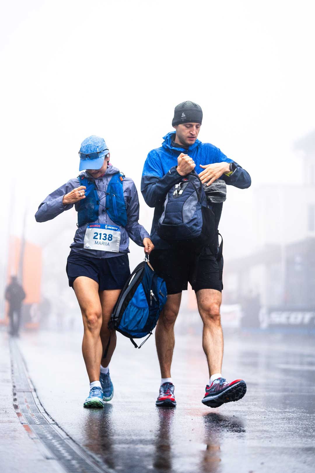 Eventfotografie: Paar läuft im Regen und Nebel – Vorbereitungen für ein Rennen