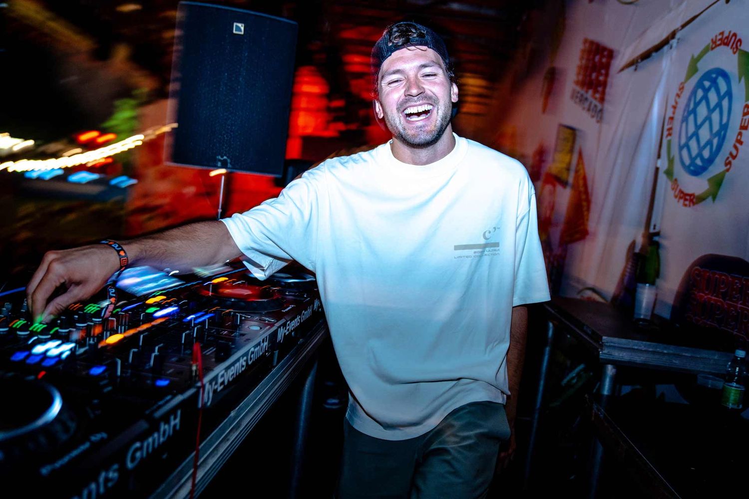 Eventfotografie: DJ Giannex lacht glücklich in die Kamera während seines Auftrittes während seinem Auftritt am Gurtenfestival