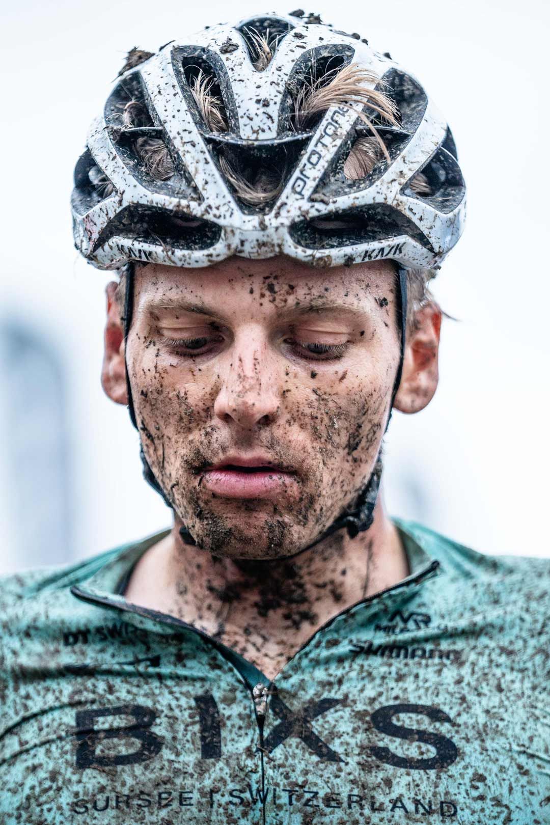 Eventfotografie: Biker mit verdrecktem Gesicht nach einem nassen Rennen
