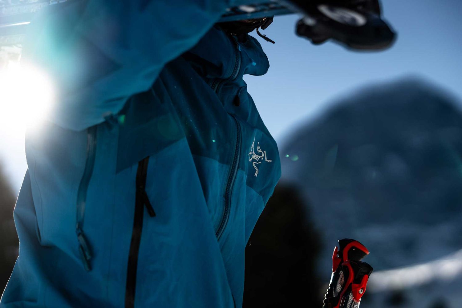Sportlifestylefotografie: Skifahrer trägt seine Ski, blaue Arcteryx Jacke – im Hintergrund die Eigernordwand