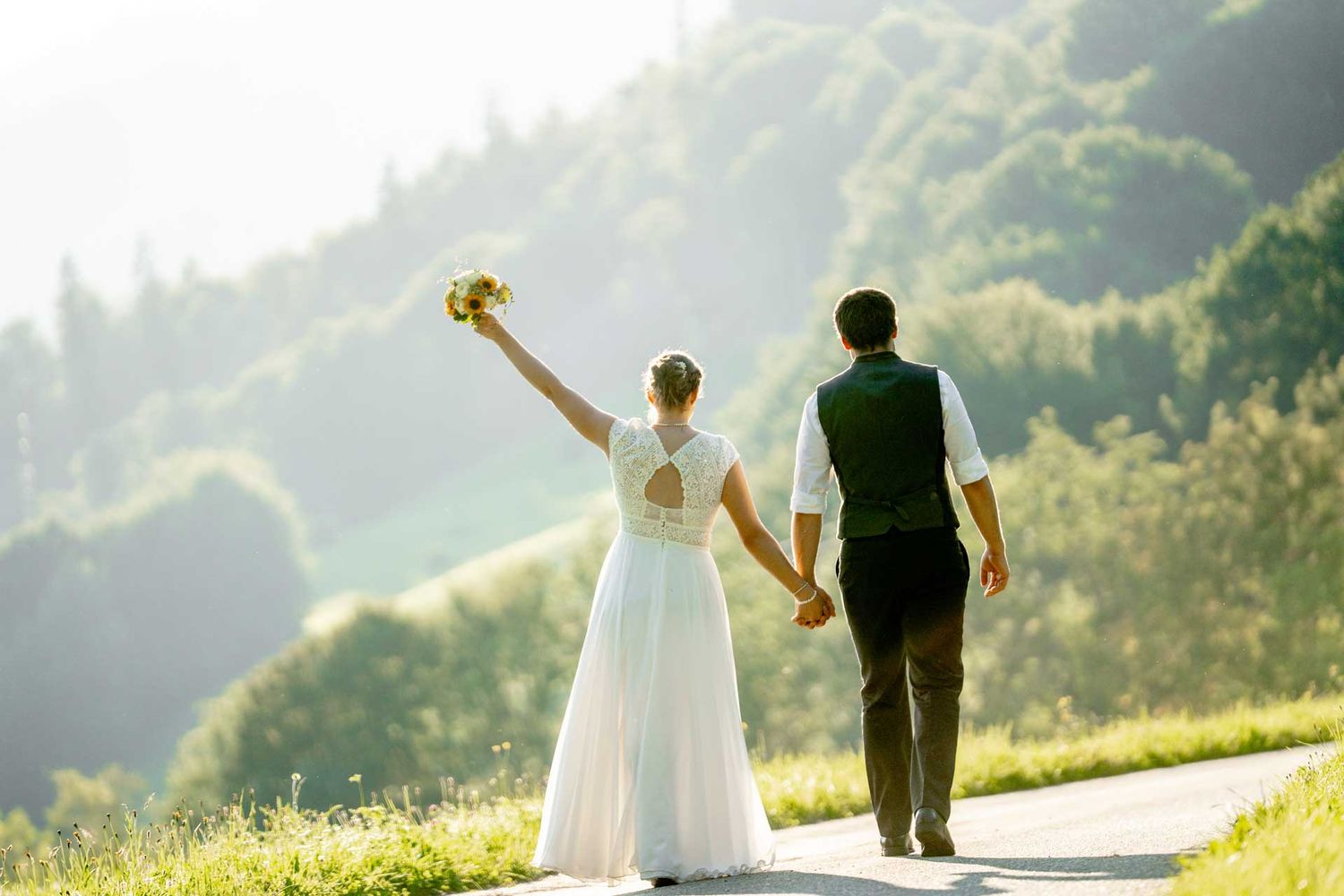 Hochzeitsfotografie: Hochzeitspaar läuft auf einer Strasse und verlässt die Hochzeit – Hand in Hand gehend.