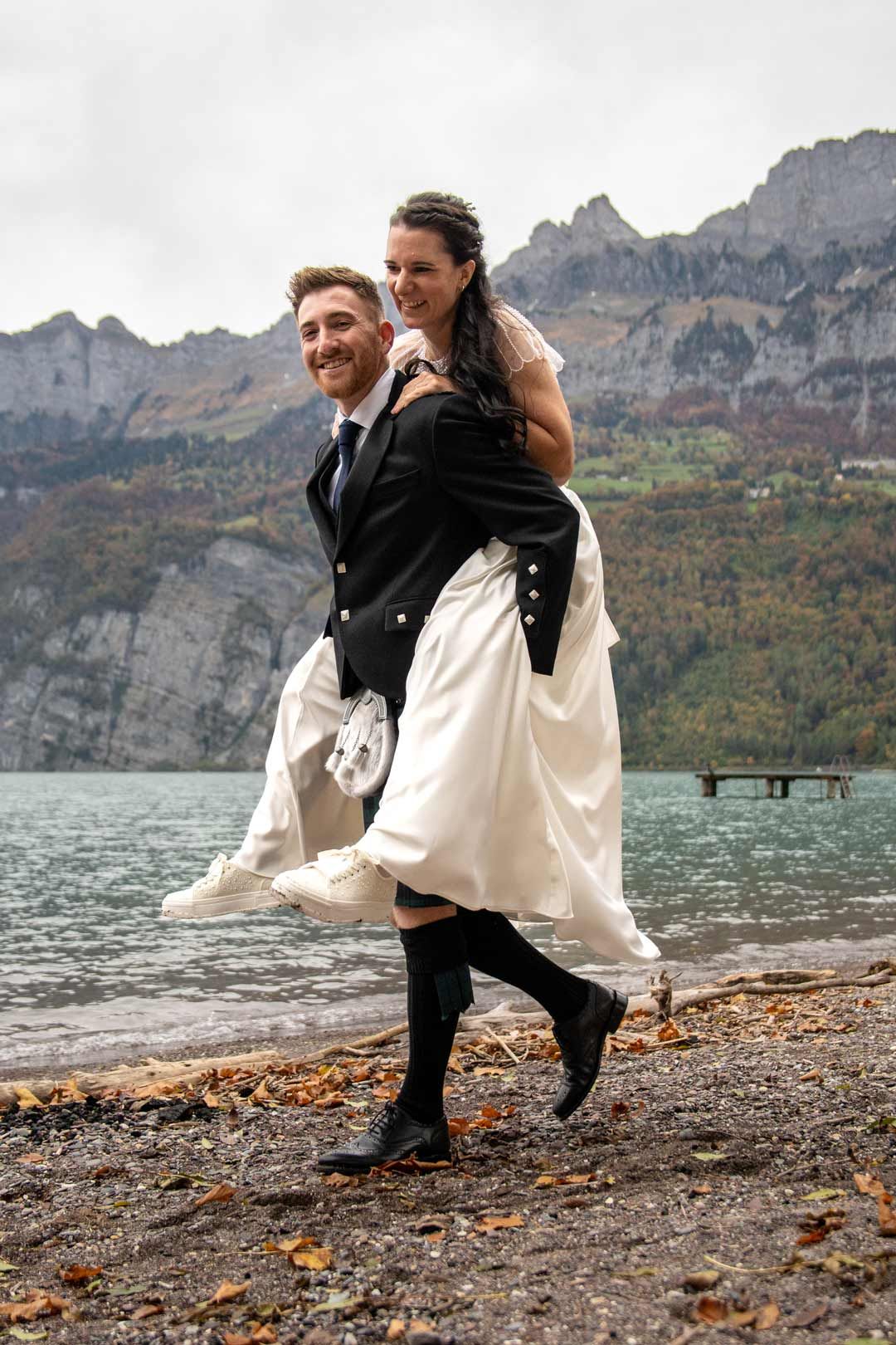 Hochzeitsfotografie: Bräutigam trägt seine Braut am See
