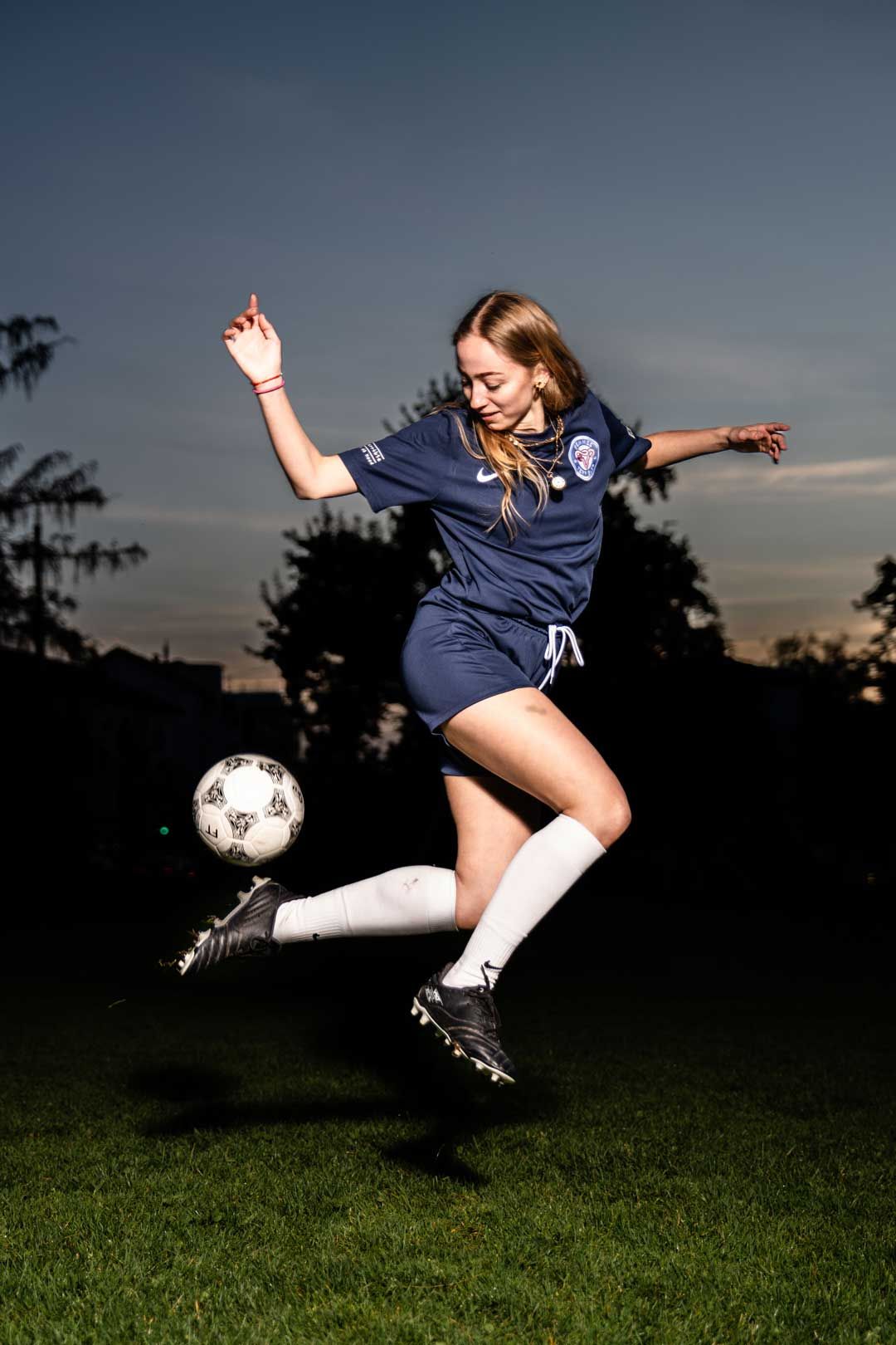 Fussballerin mit Trick umgesetzt mit Blitz während eines Fotoshooting