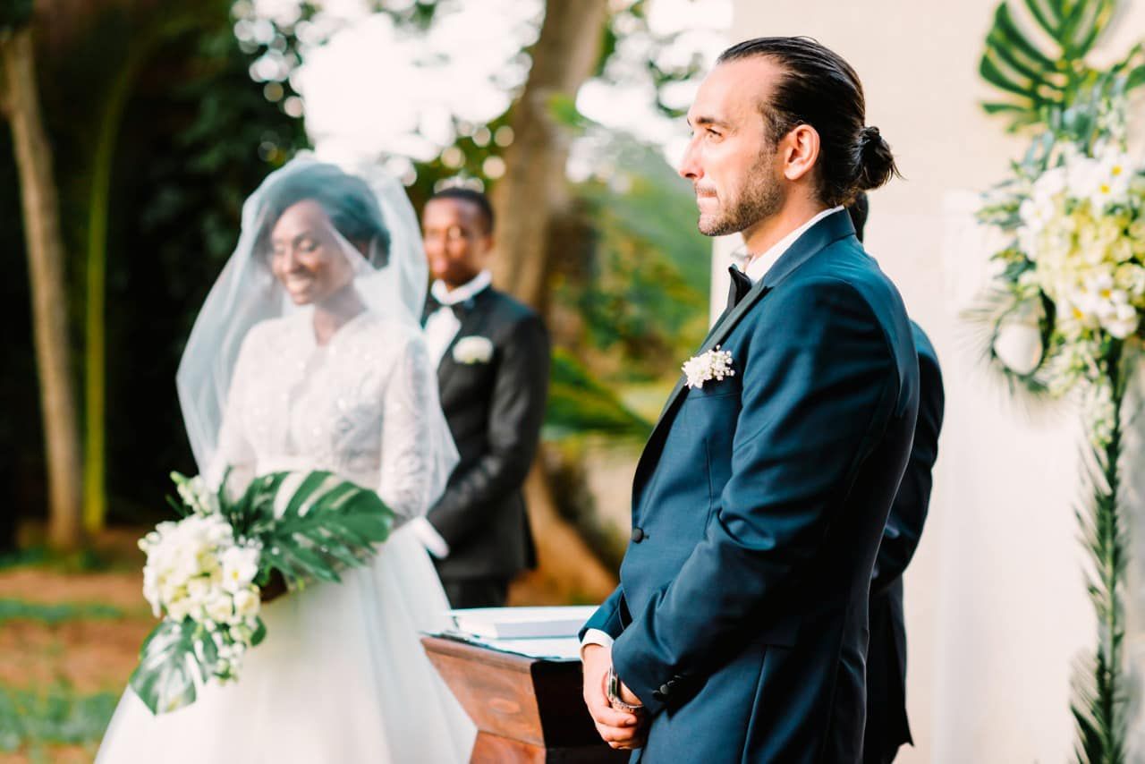 A romantic wedding couple shares intimate moments in a garden setting with lush greenery and natural lighting.