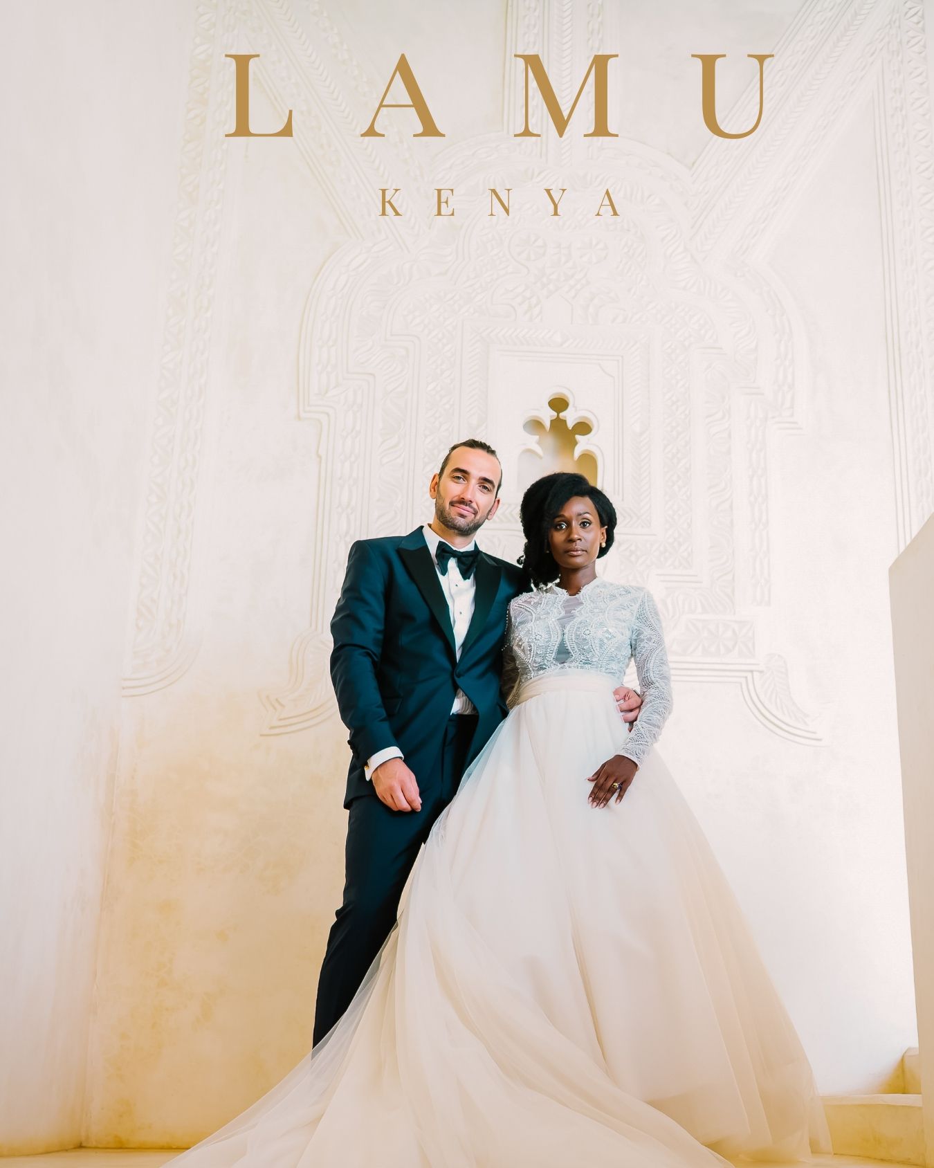Elegant wedding celebration in Lamu, Kenya with couple posing against white backdrop with gold lettering.