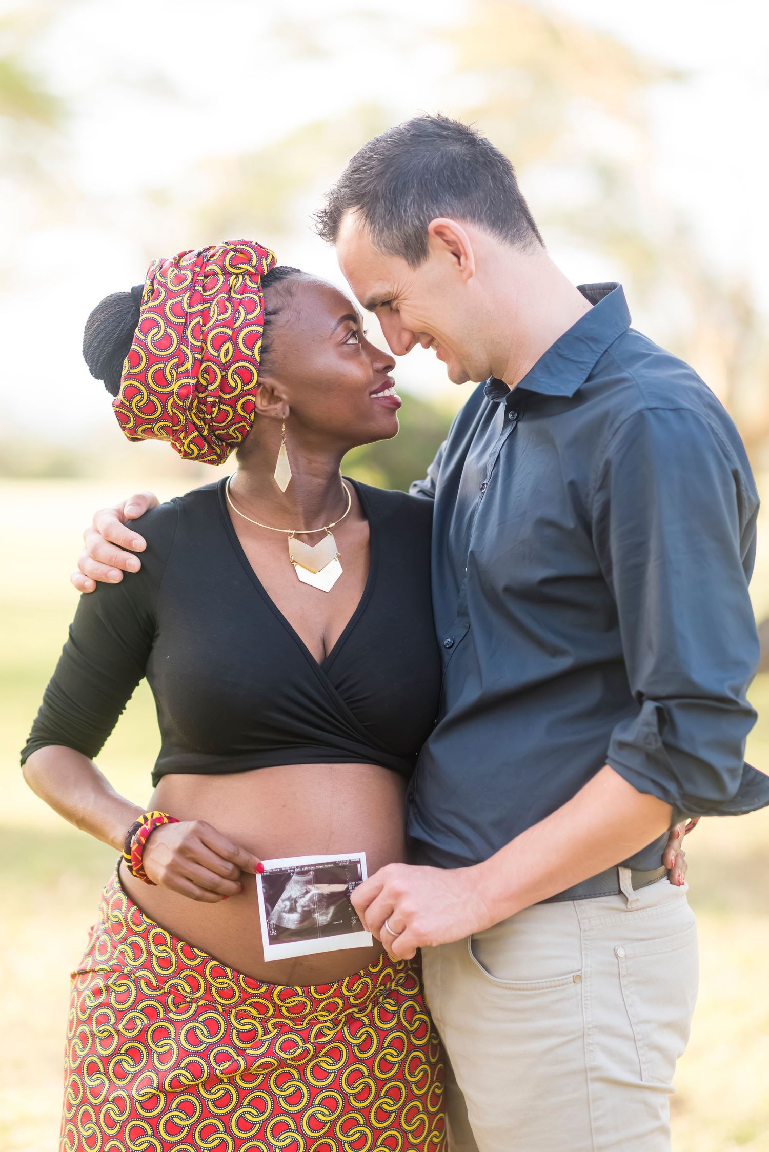 Couple sharing intimate moments outdoors in casual attire.