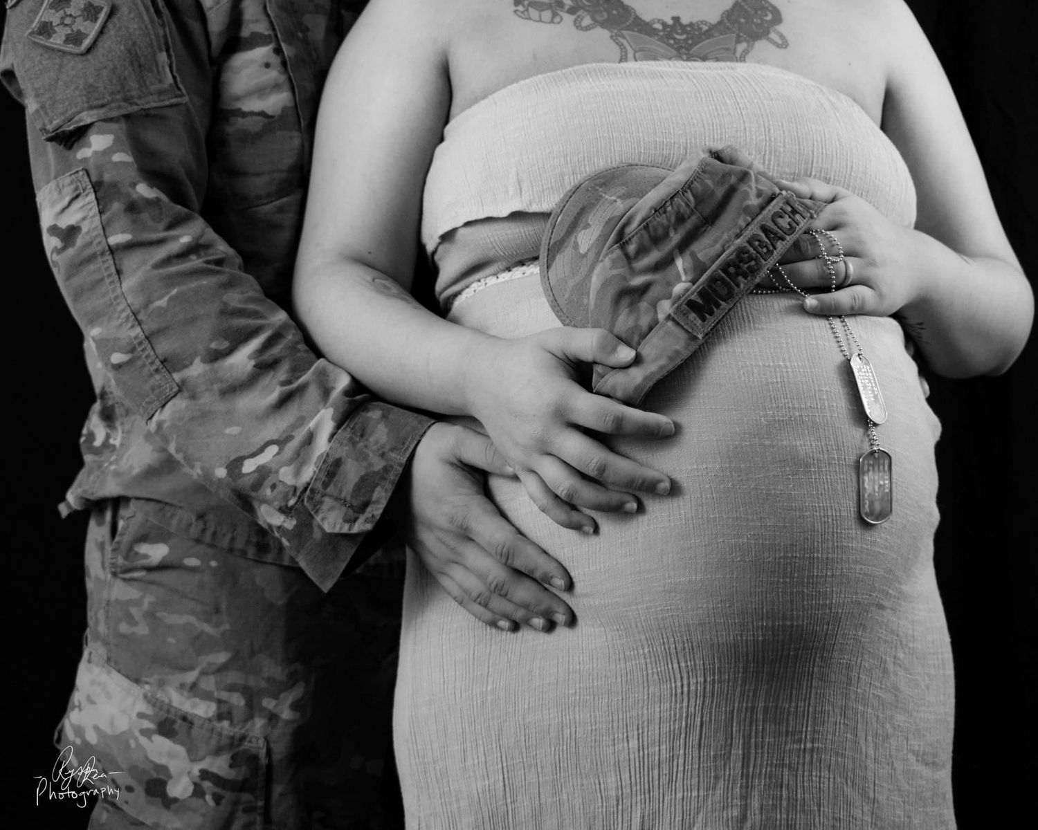 Black and white military maternity photo series showing hands on belly.