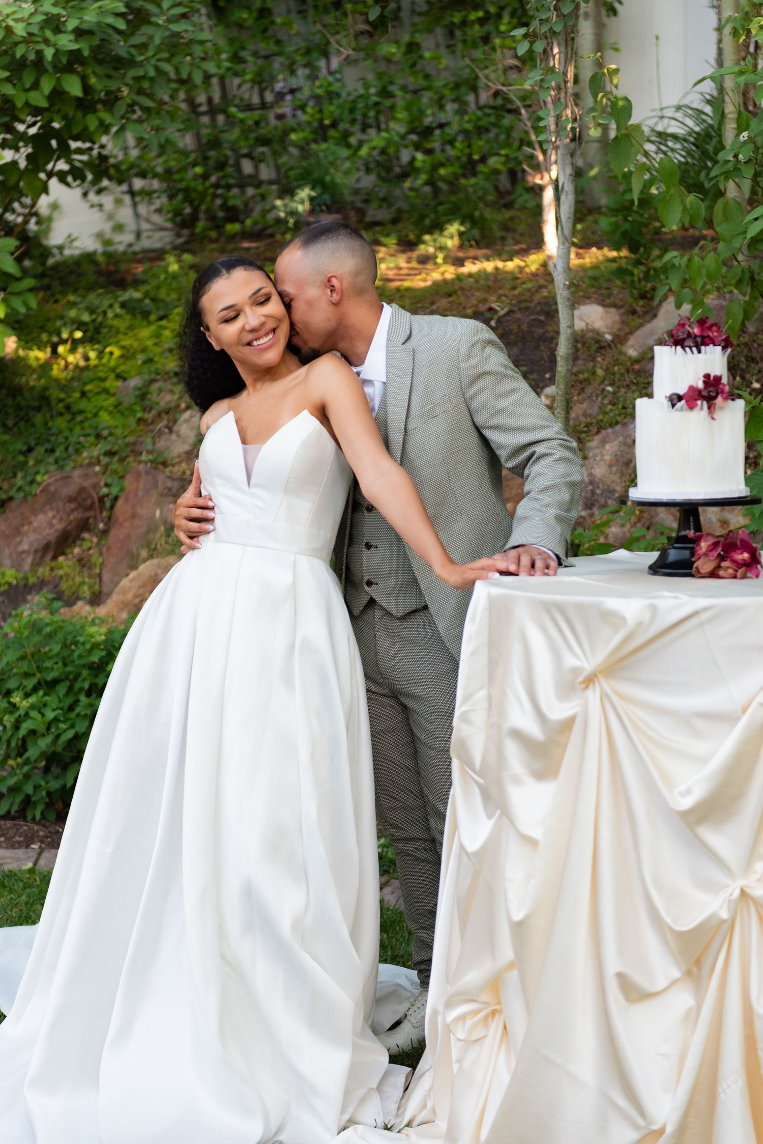 Romantic wedding portraits in a garden setting with white dress and gray suit.