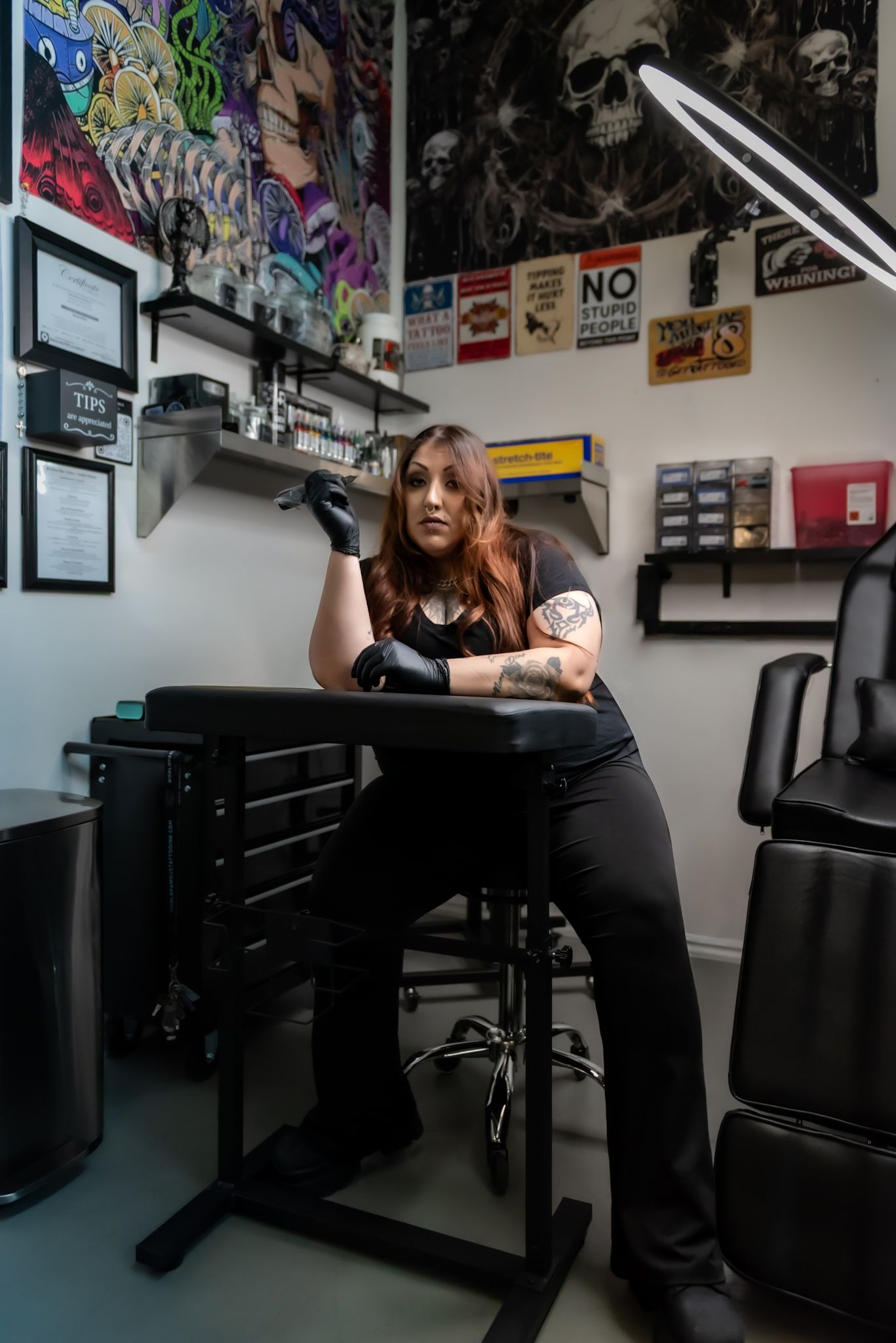Interior workspace decorated with posters and graffiti art features dark furniture and equipment.