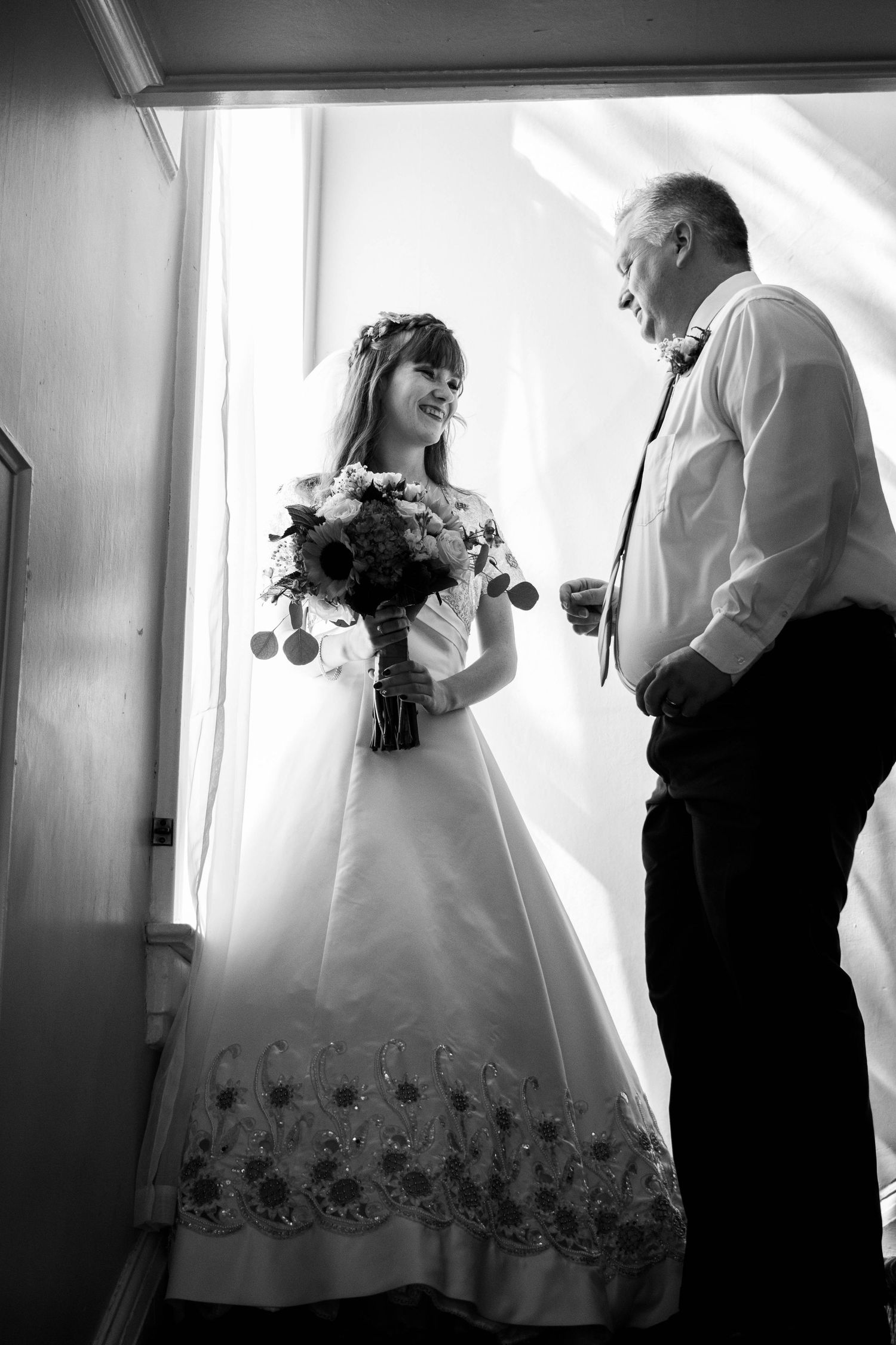 Black and white wedding photos showing tender moments between couple in formal attire.