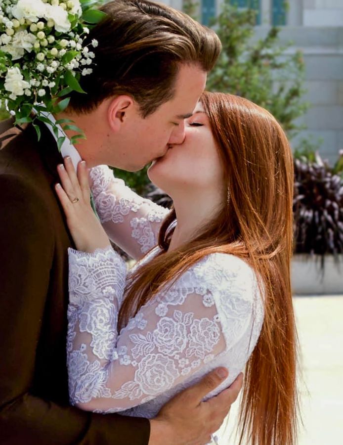 Romantic wedding portrait showing couple in lace dress and formal attire.