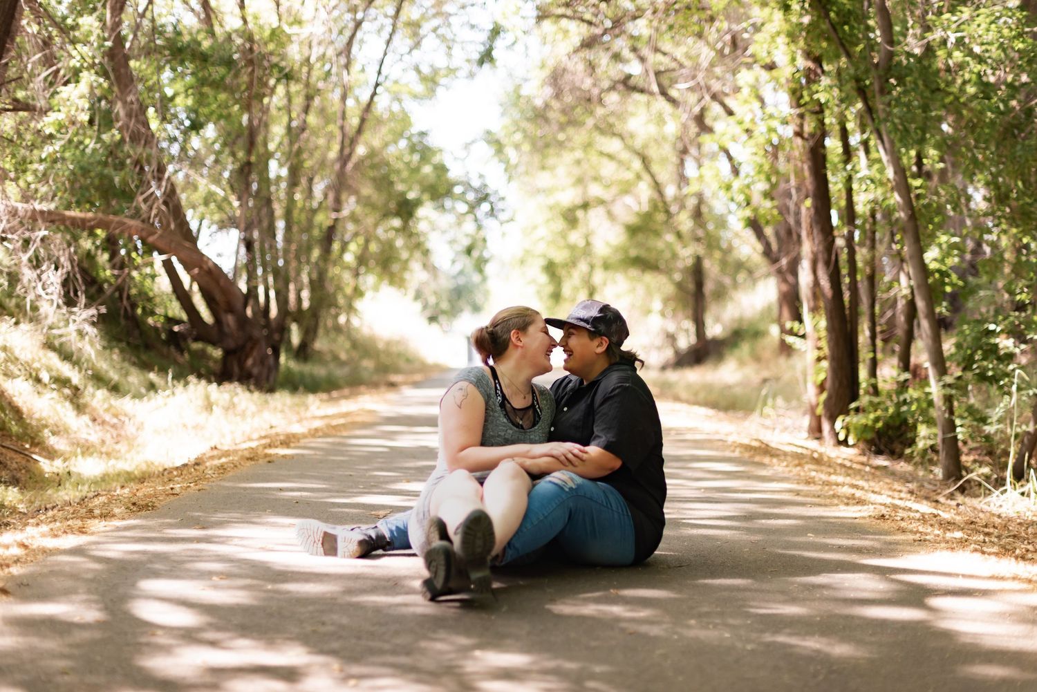 A romantic couple's photoshoot on a tree-lined dirt path.