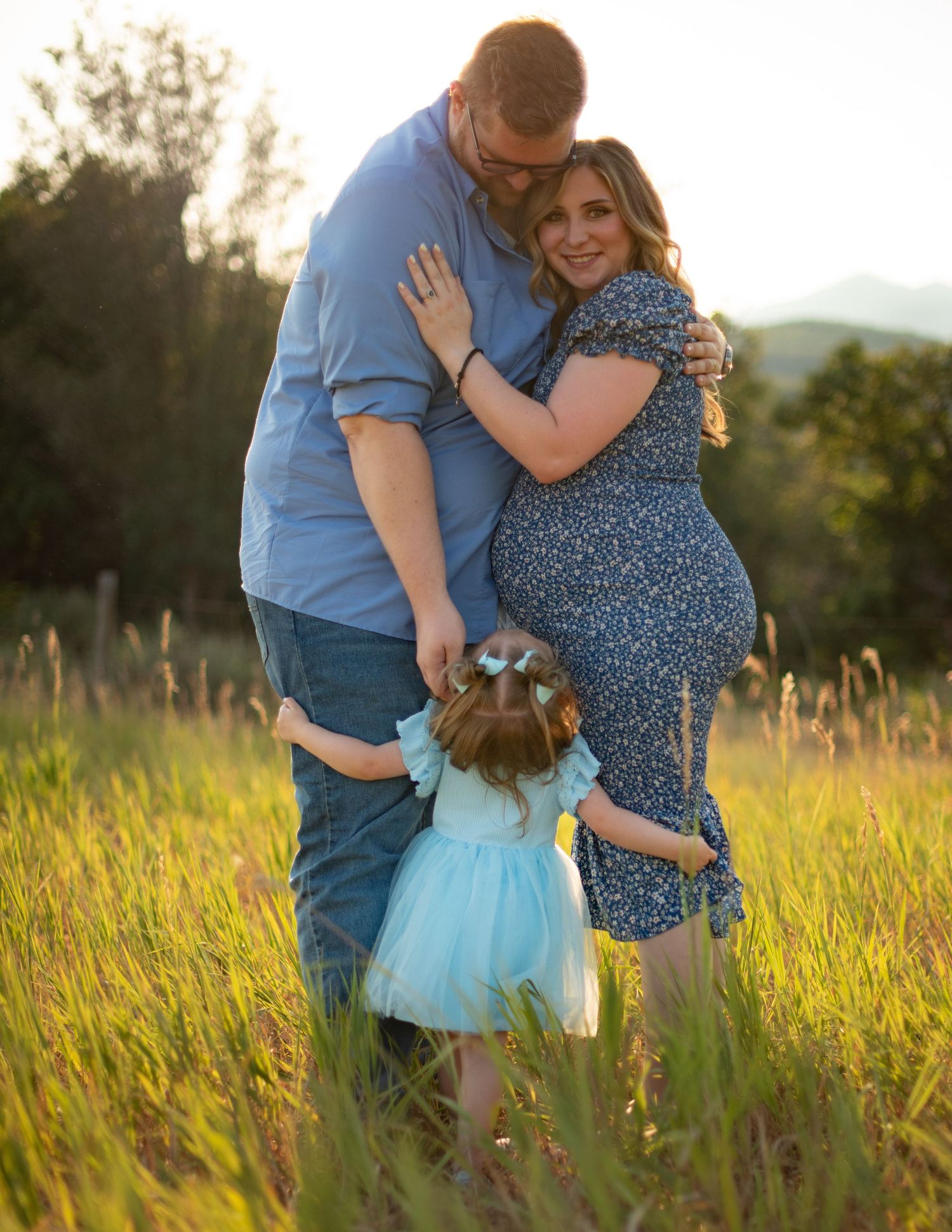 Family portrait session in a golden meadow during sunset.