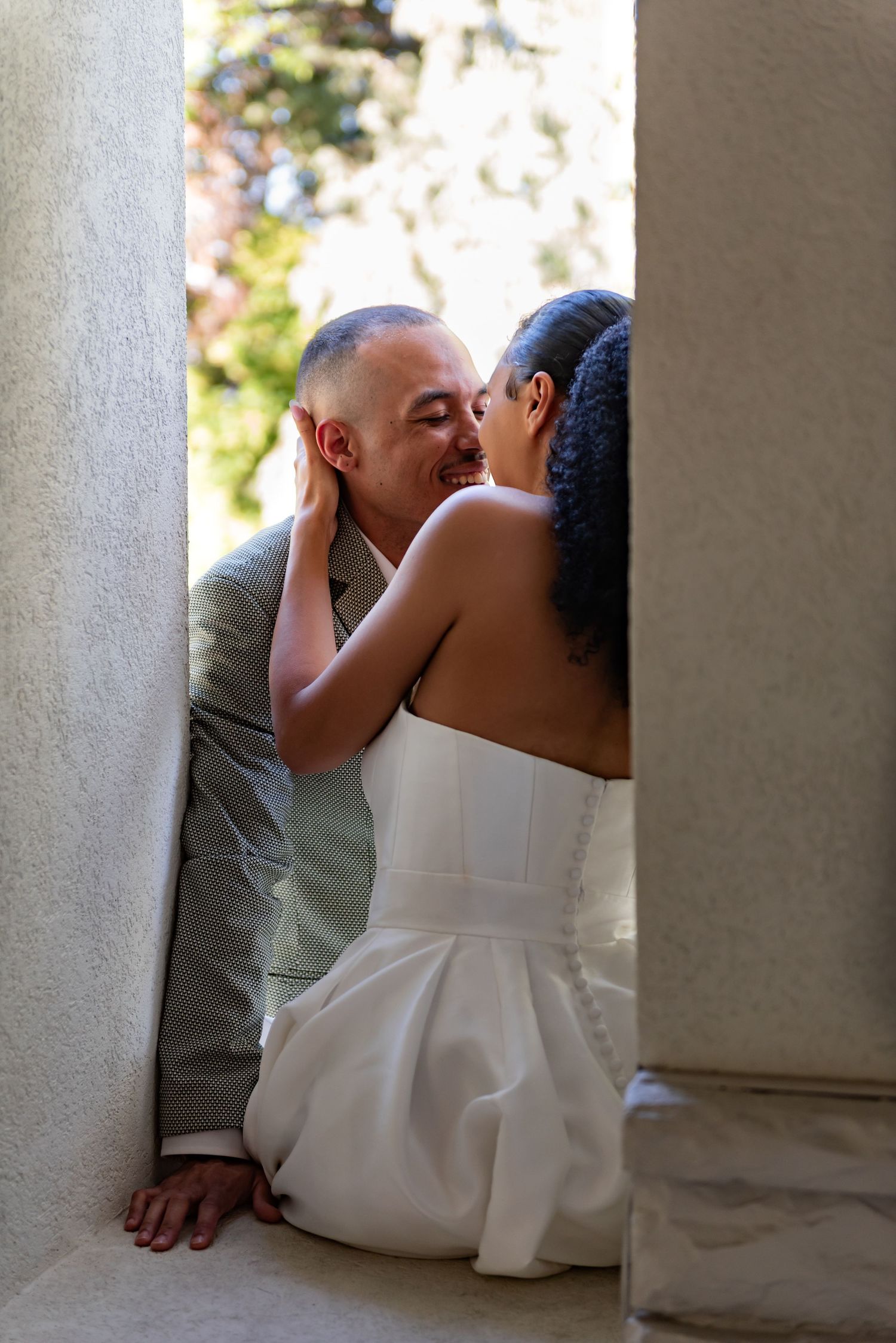 A romantic moment captured between a couple near white stone columns.