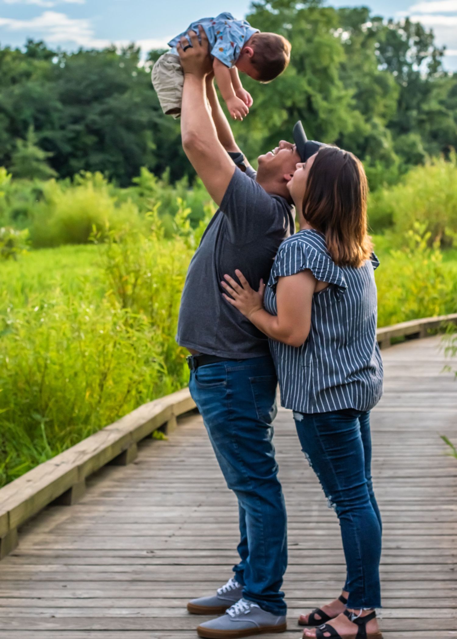 Couple sharing romantic moment on wooden boardwalk in casual attire.