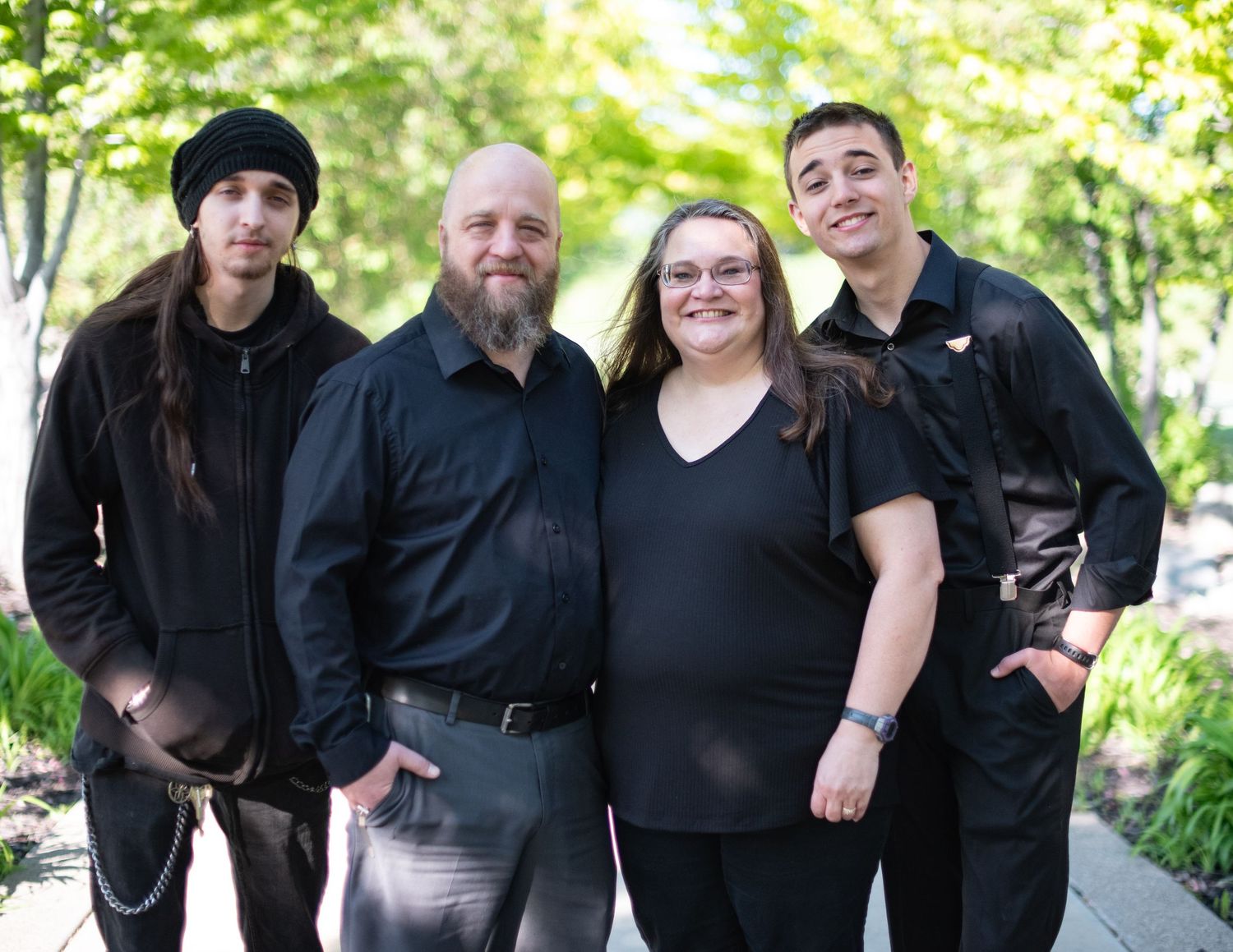 Family group portrait outdoors with everyone dressed in black casual attire.