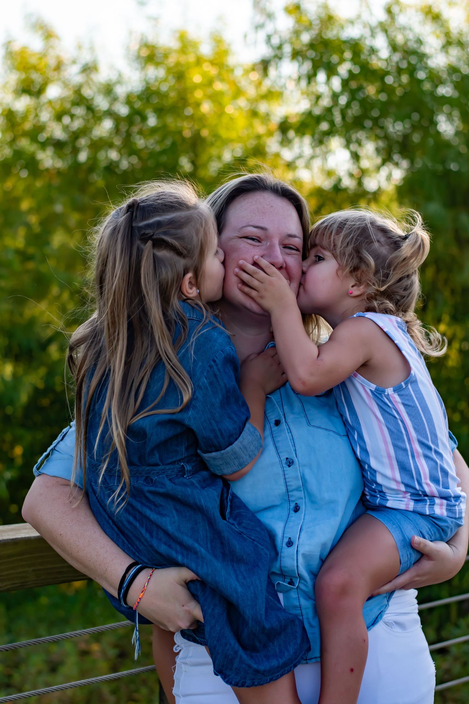 Sweet candid moment captured of affectionate embraces on a wooden deck at sunset.