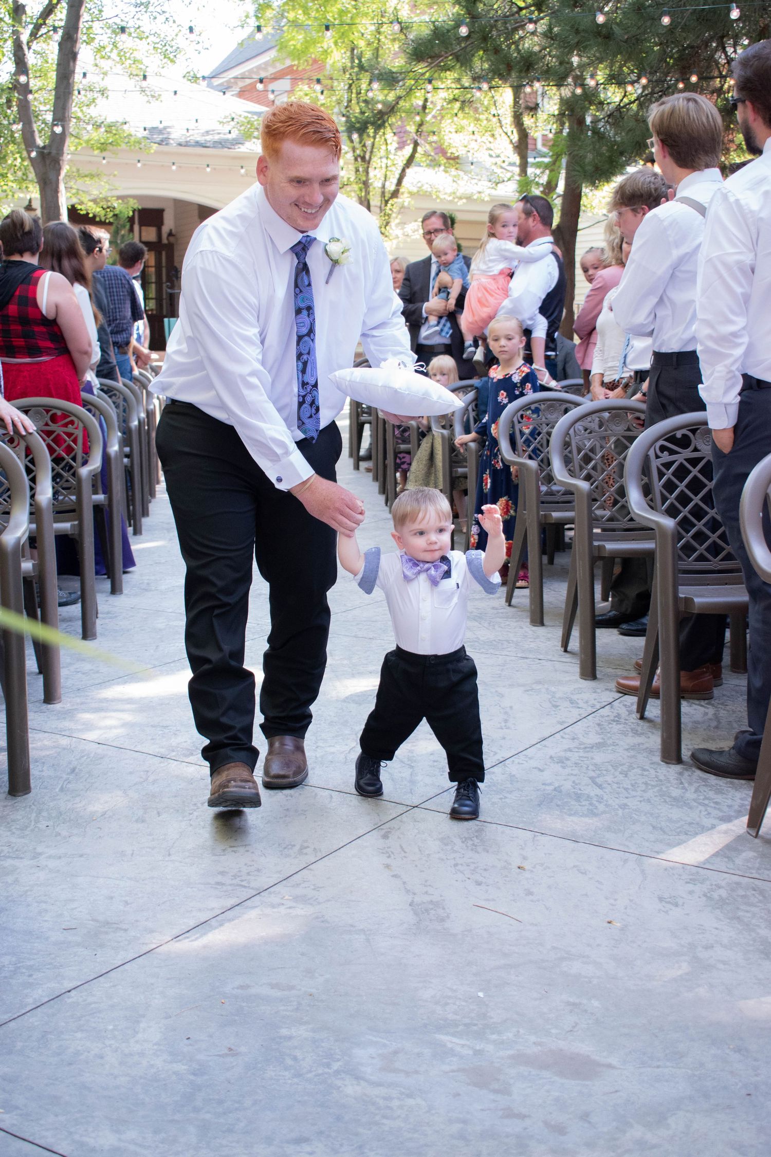Children playing and running down a concrete path at a wedding reception.