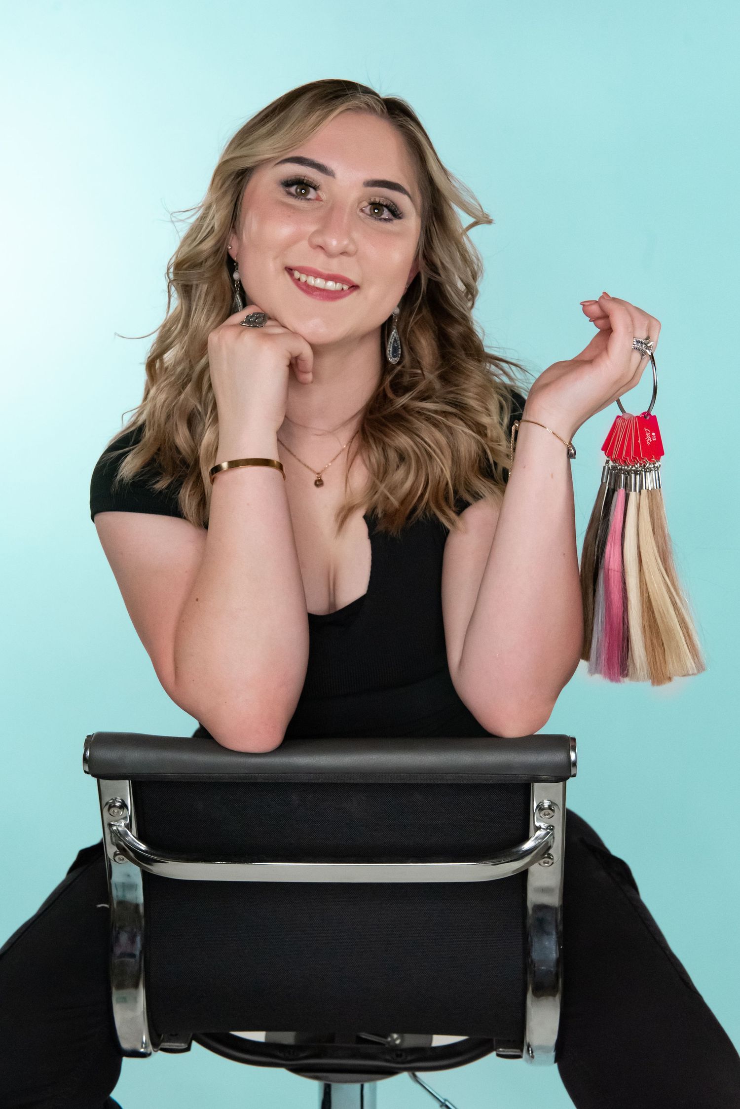 Studio portrait showing colorful tassels and accessories against a teal background.