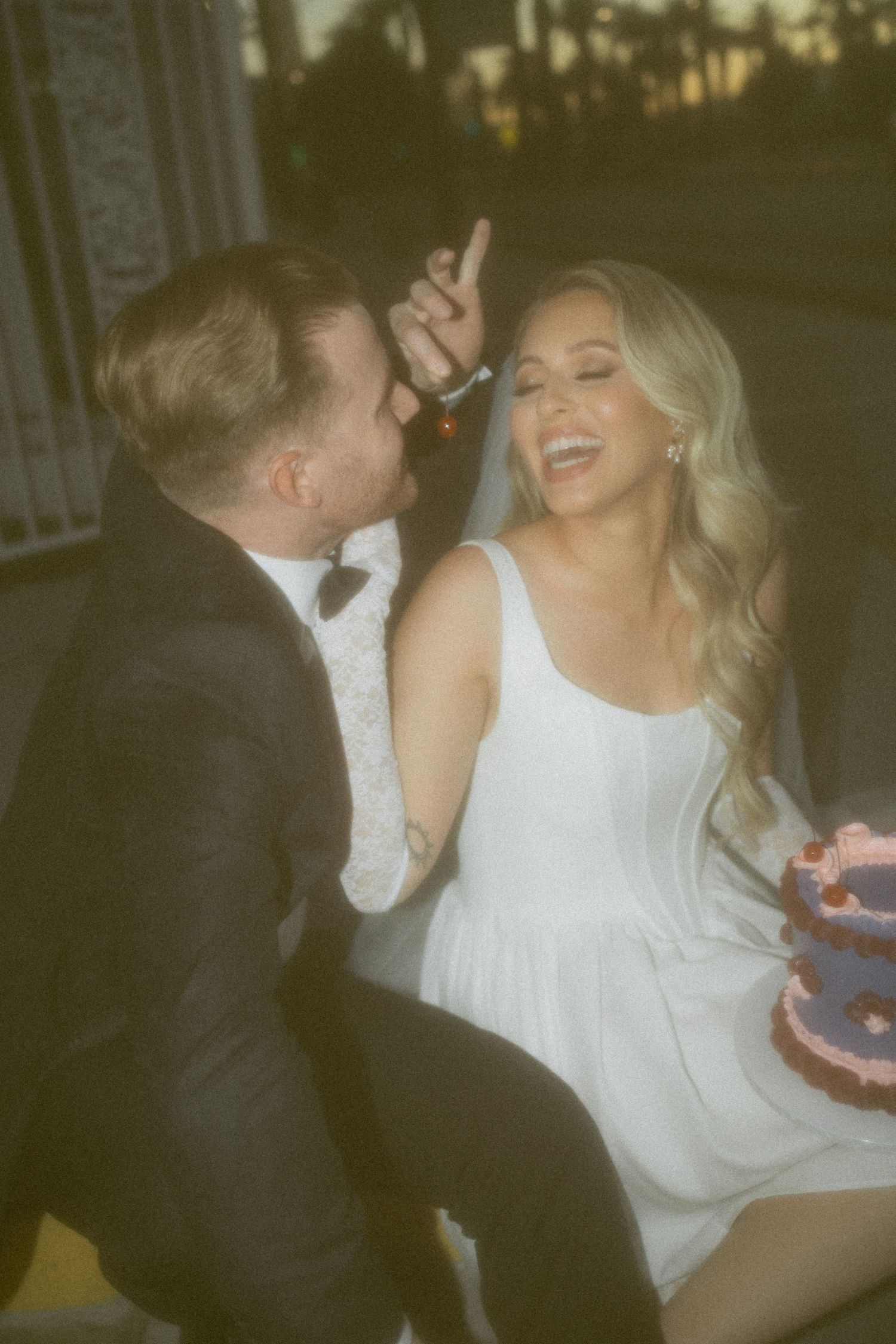 A joyful wedding celebration outside Little White Chapel at dusk.