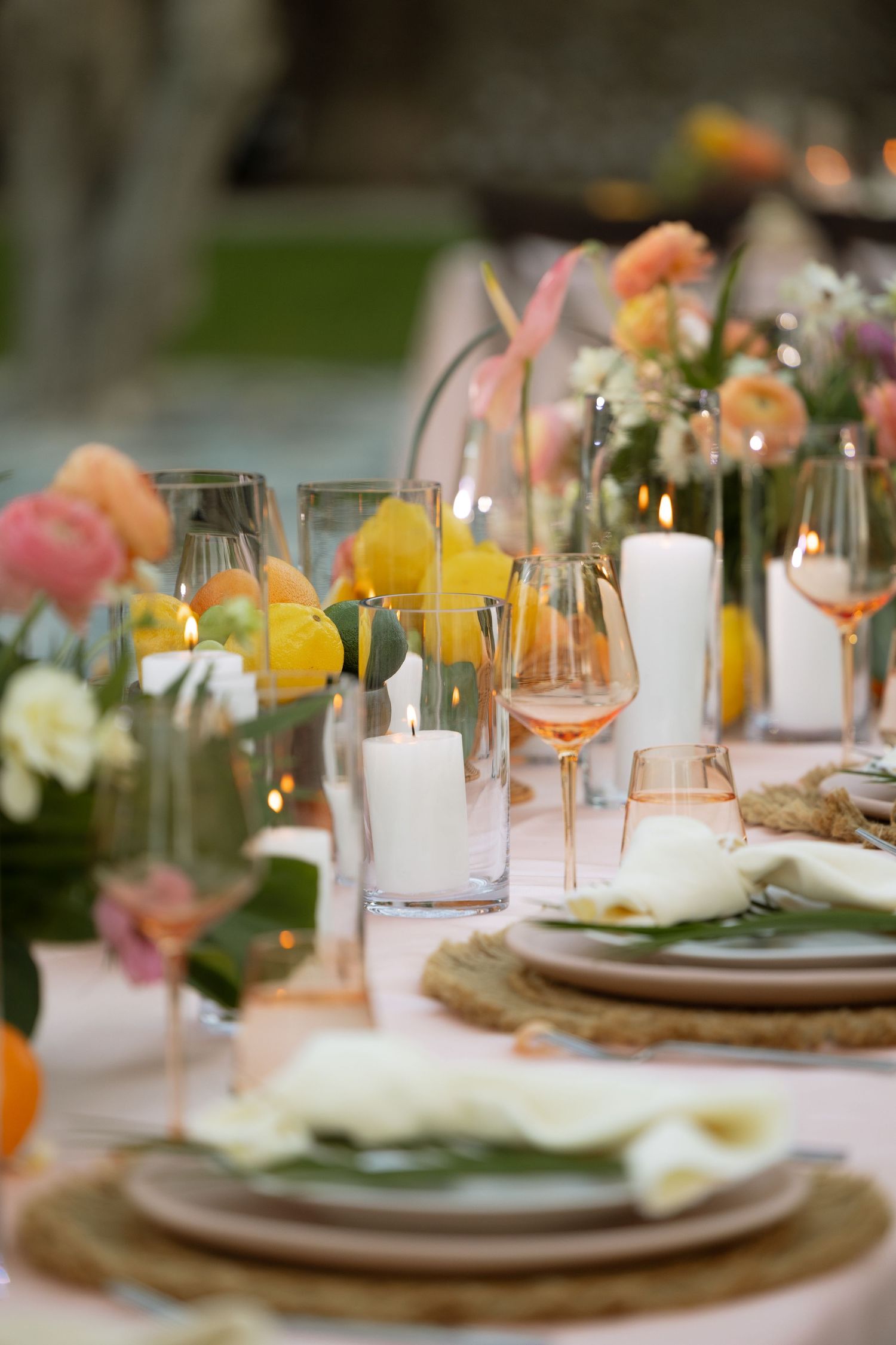 A beautifully styled wedding reception table with candles, florals, and elegant glassware.