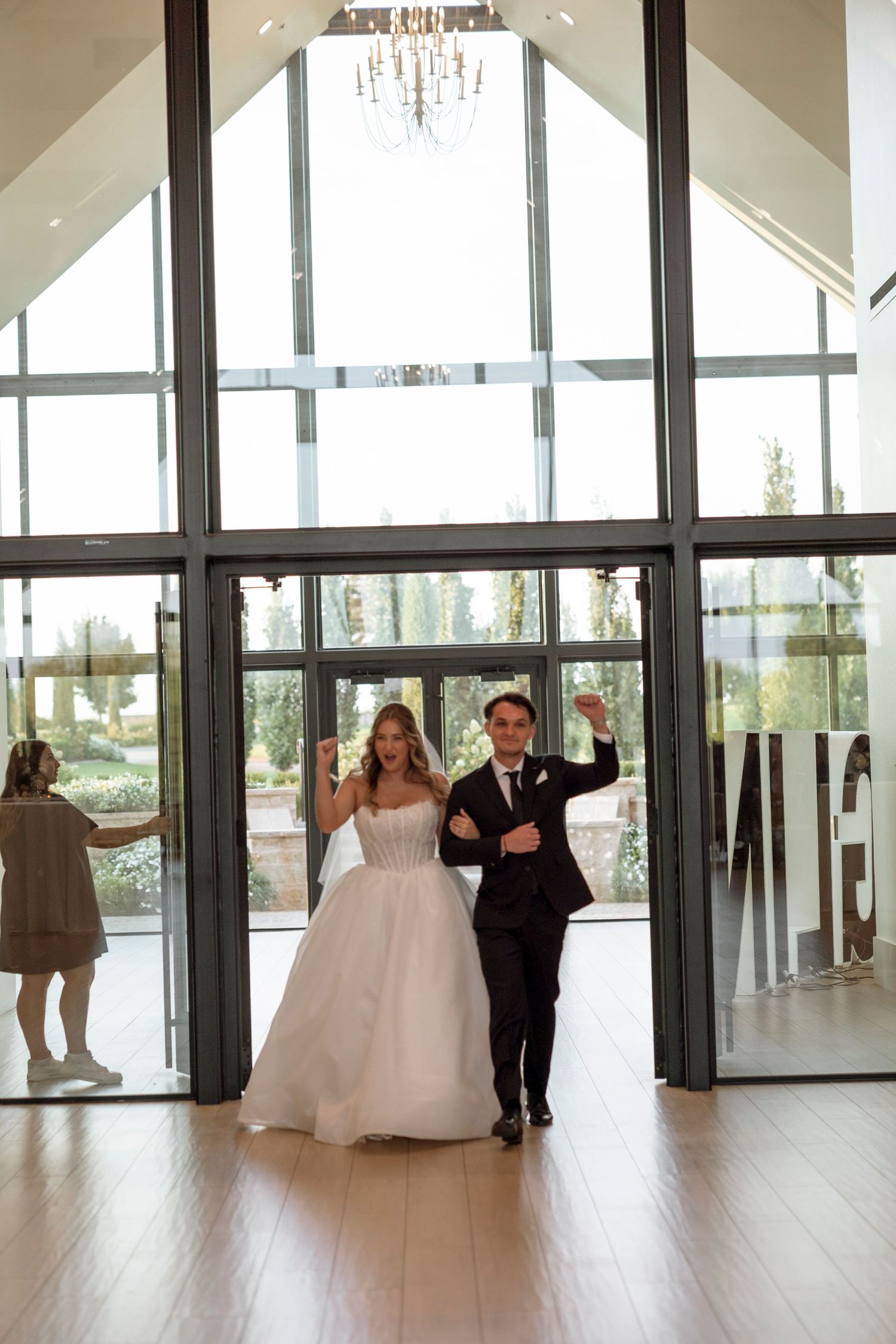 Modern wedding venue with floor-to-ceiling windows and natural light streaming in.