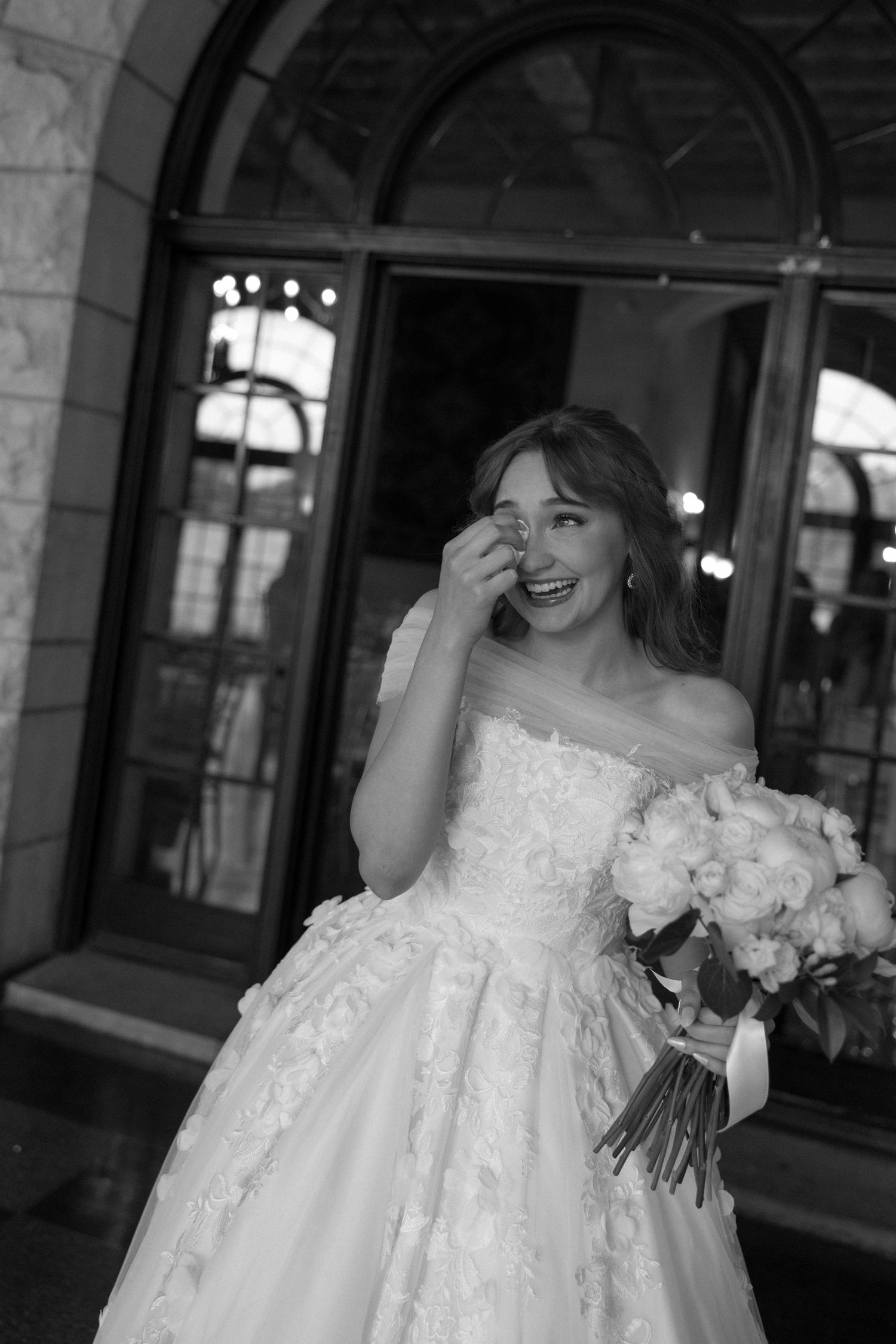 Elegant bridal moment captured in front of stone archway.