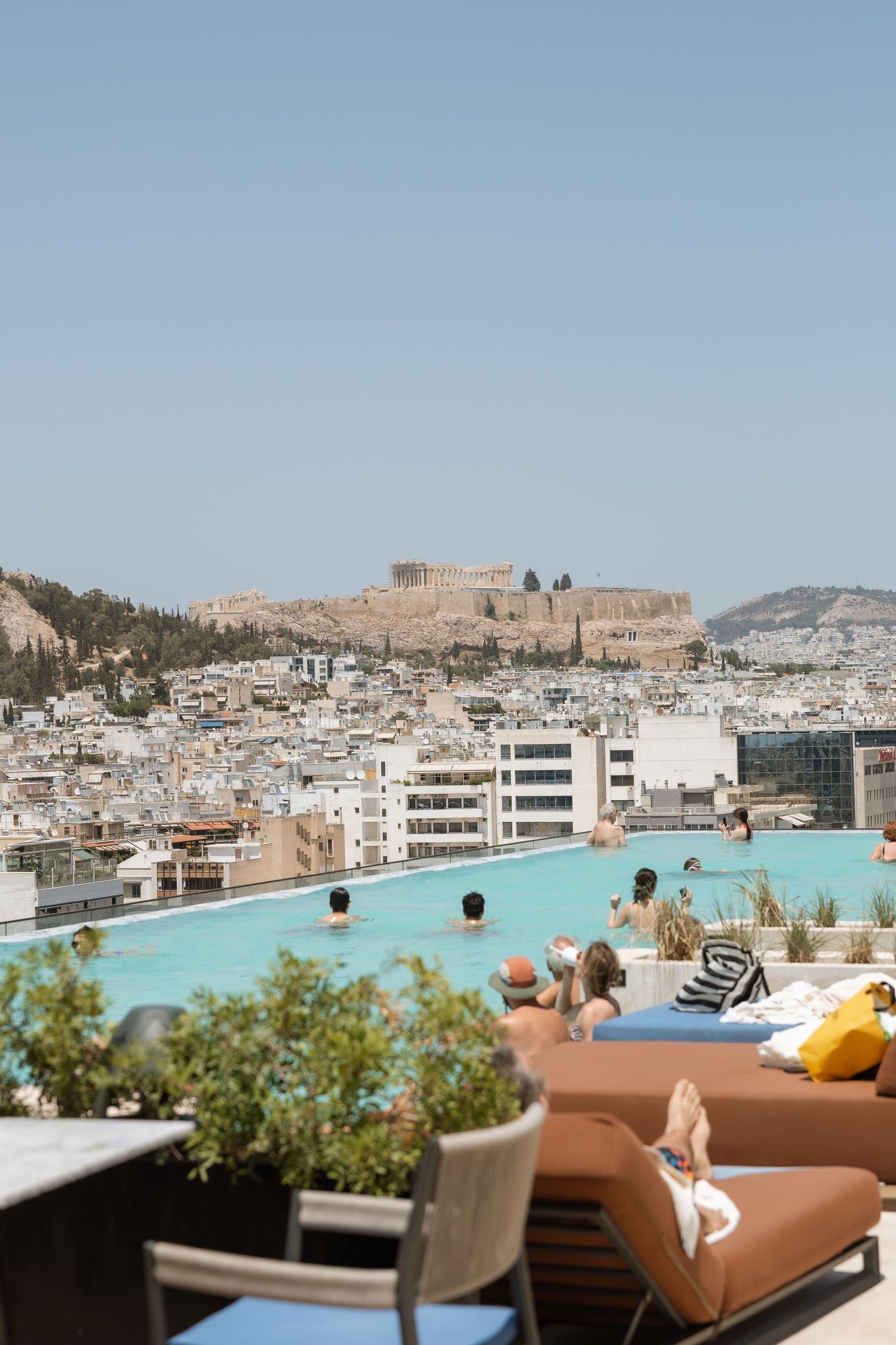 Rooftop pool with view of the Acropolis and Athens cityscape.
