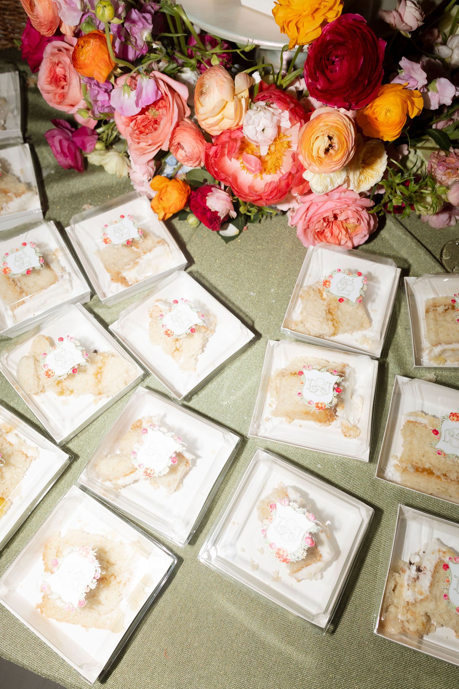 Elegant place cards arranged on a table with vibrant pink, orange and red floral decorations.