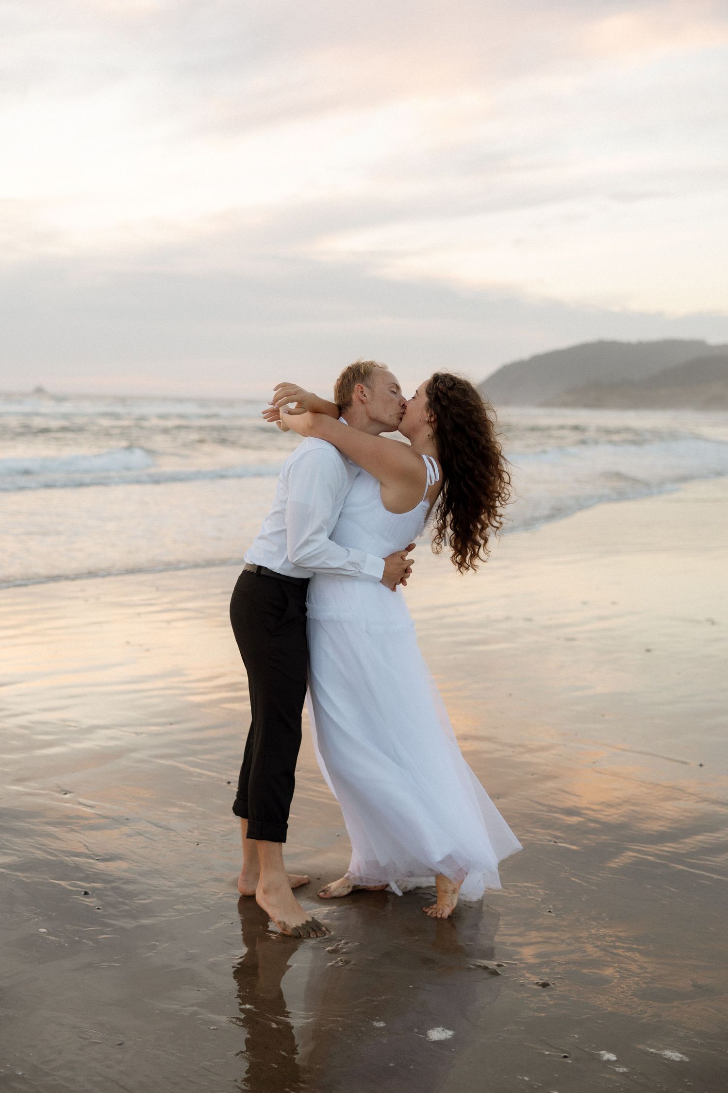 A romantic spin dance on the beach at sunset with waves rolling in.