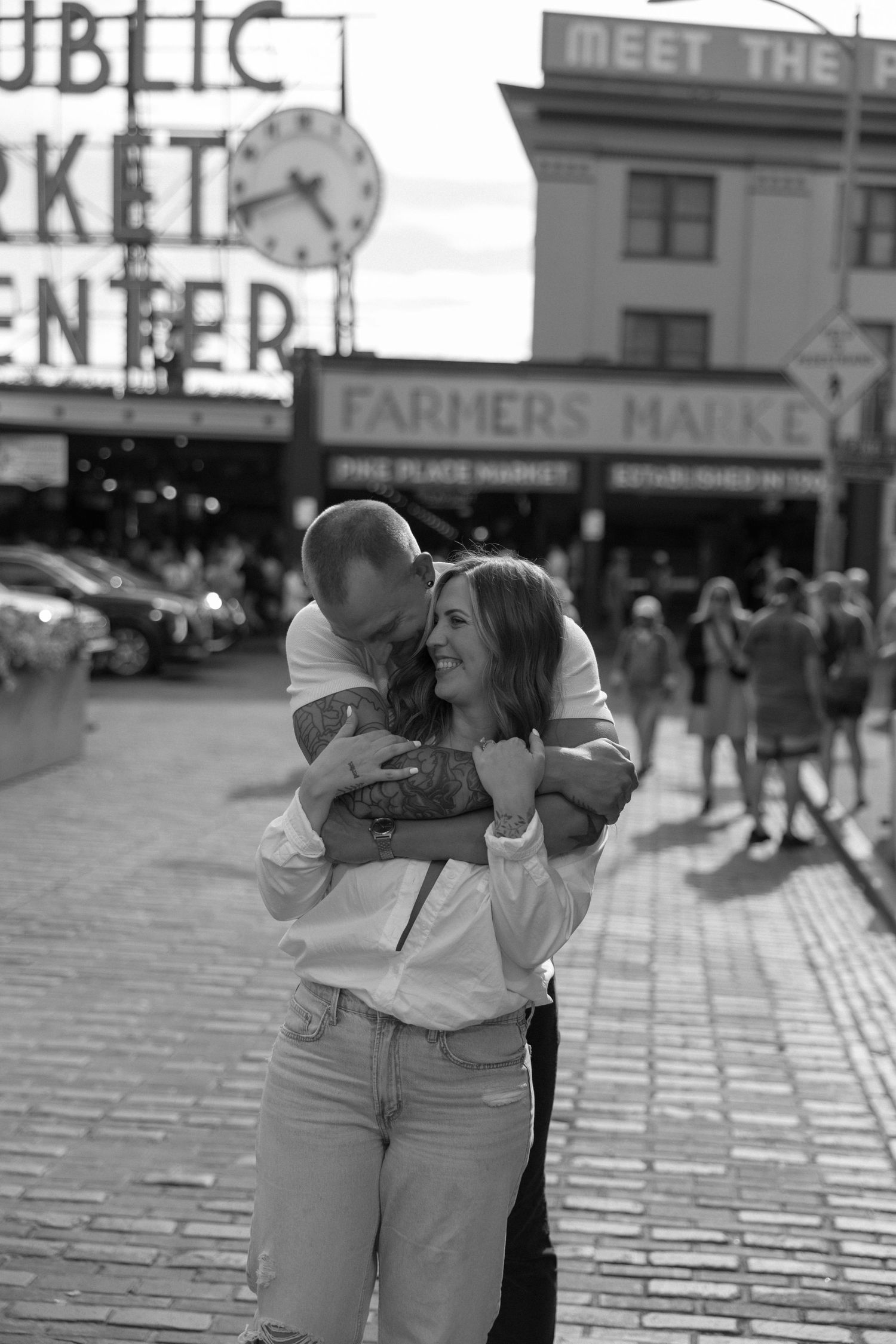 Black and white photo of a tender moment outside Pike Place Public Market in Seattle.