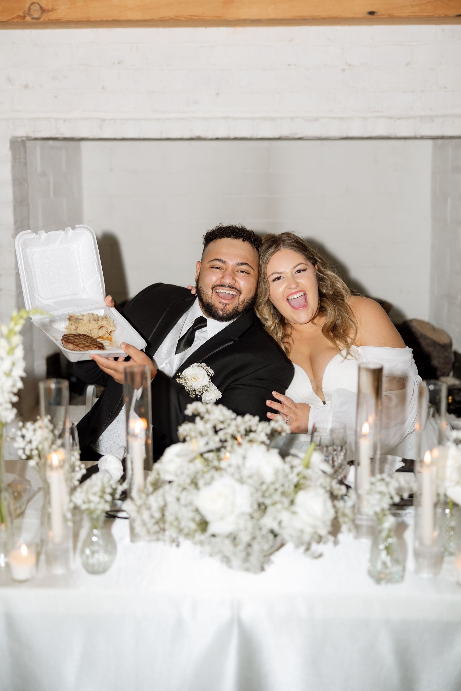 A candid moment of joy captured at the wedding reception sweetheart table.