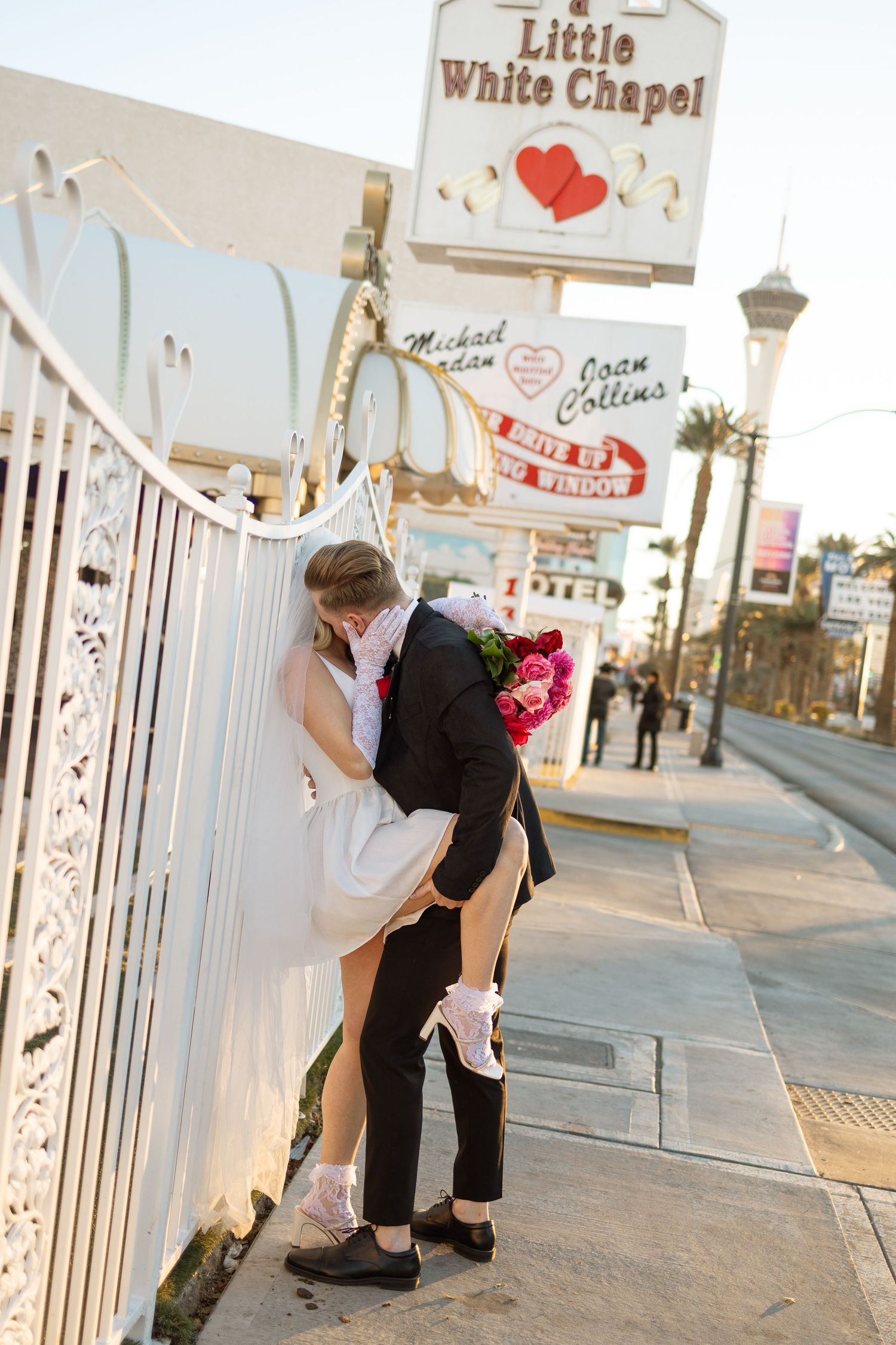 A romantic moment against the white fence at Las Vegas' Little White Chapel.