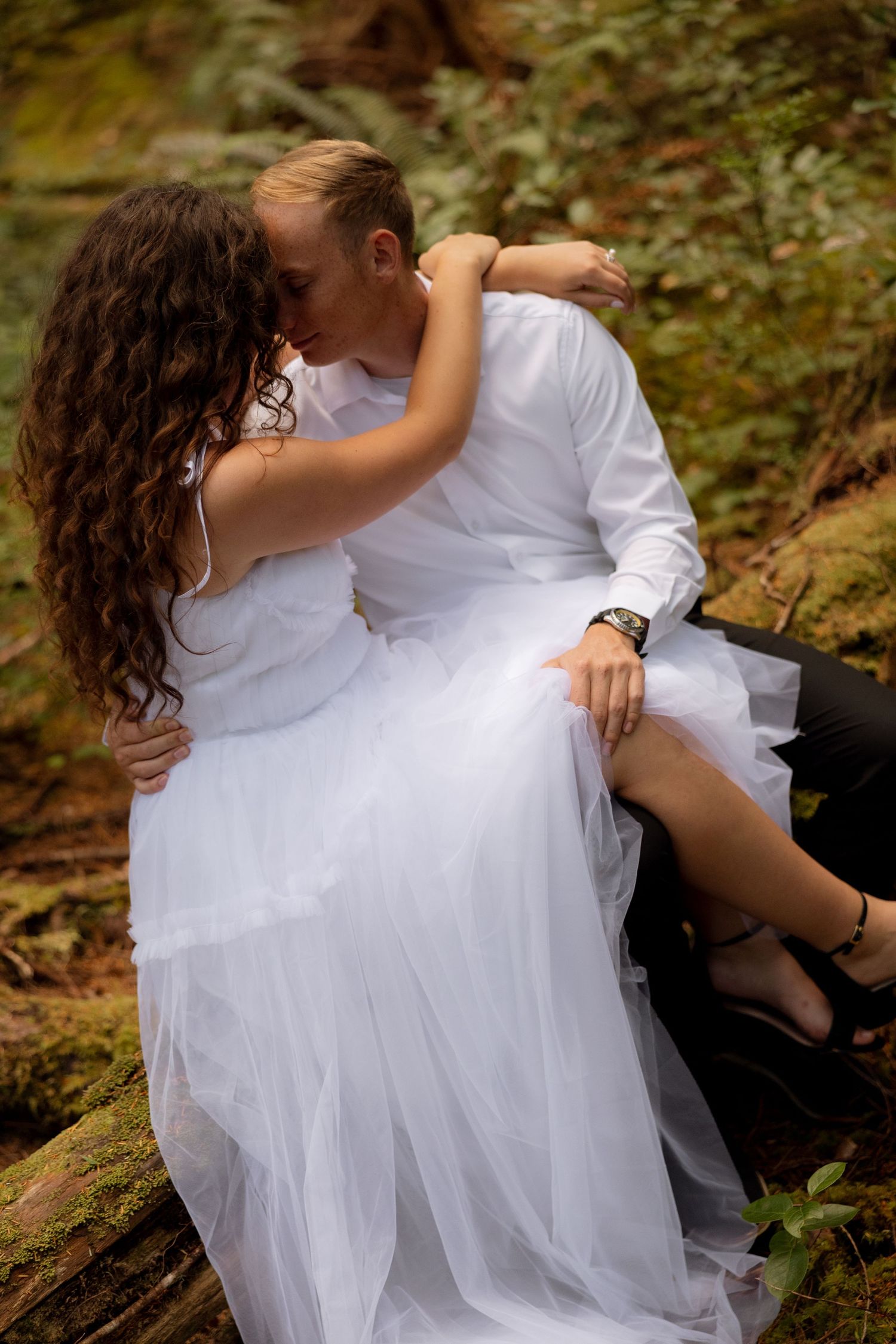 An intimate wedding moment captured in a forest setting.