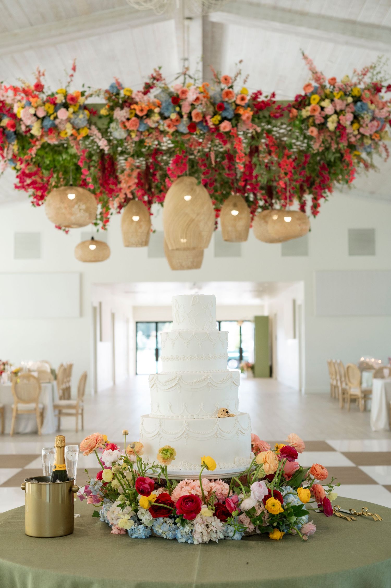 Elegant wedding reception venue with colorful floral arrangements and a white wedding cake on display.