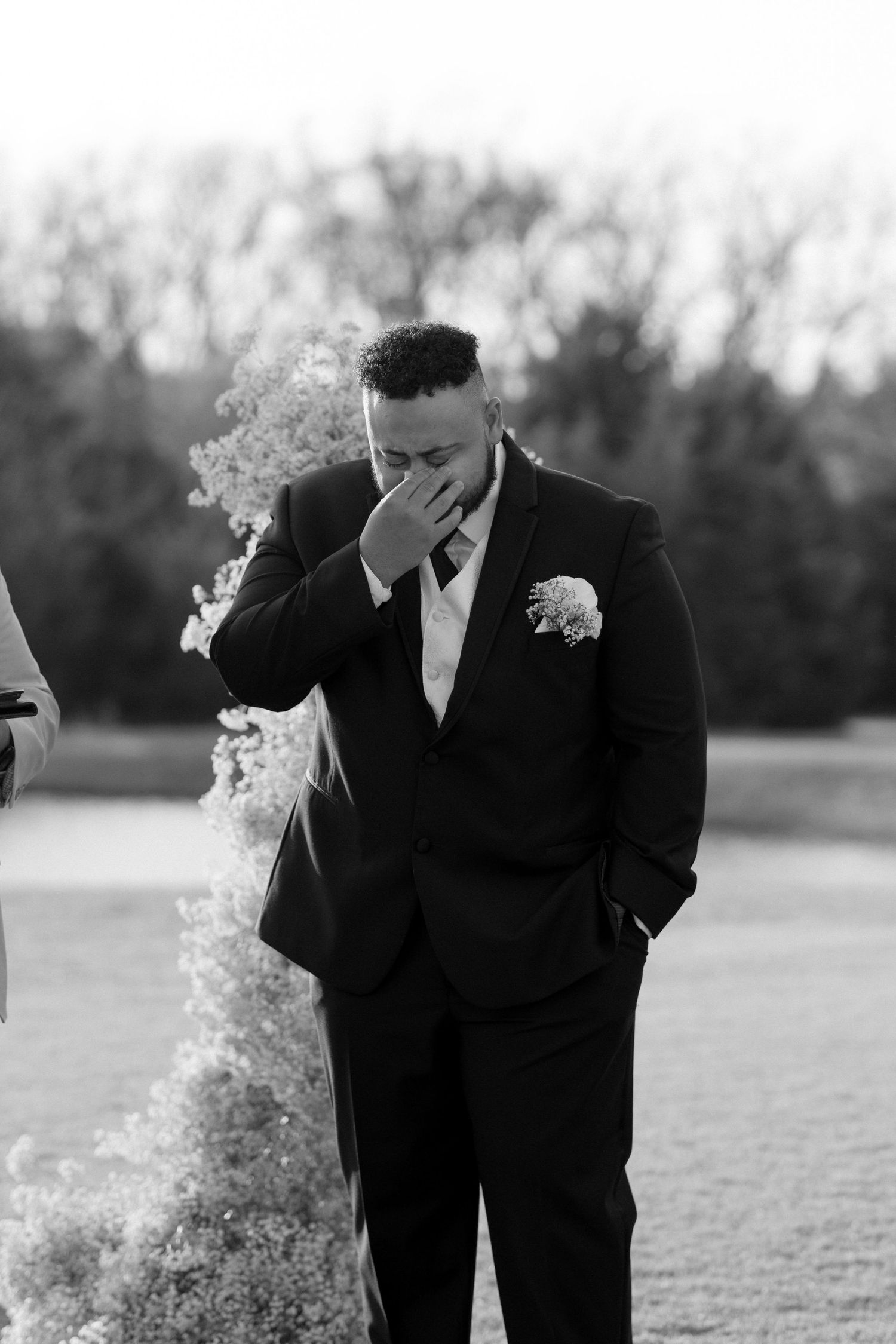 Emotional black and white moment captured during outdoor wedding ceremony.