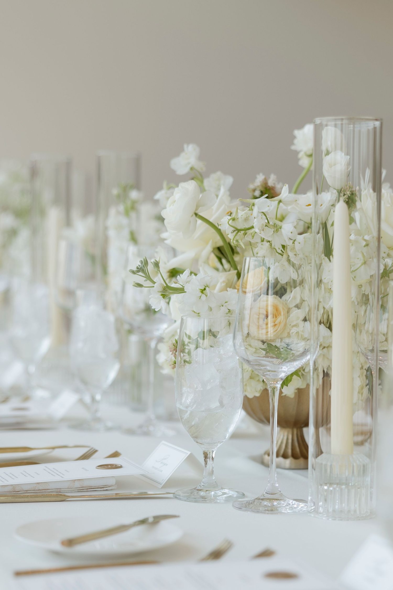 Elegant white floral table settings with crystal glassware and delicate centerpieces create a sophisticated dining atmosphere.