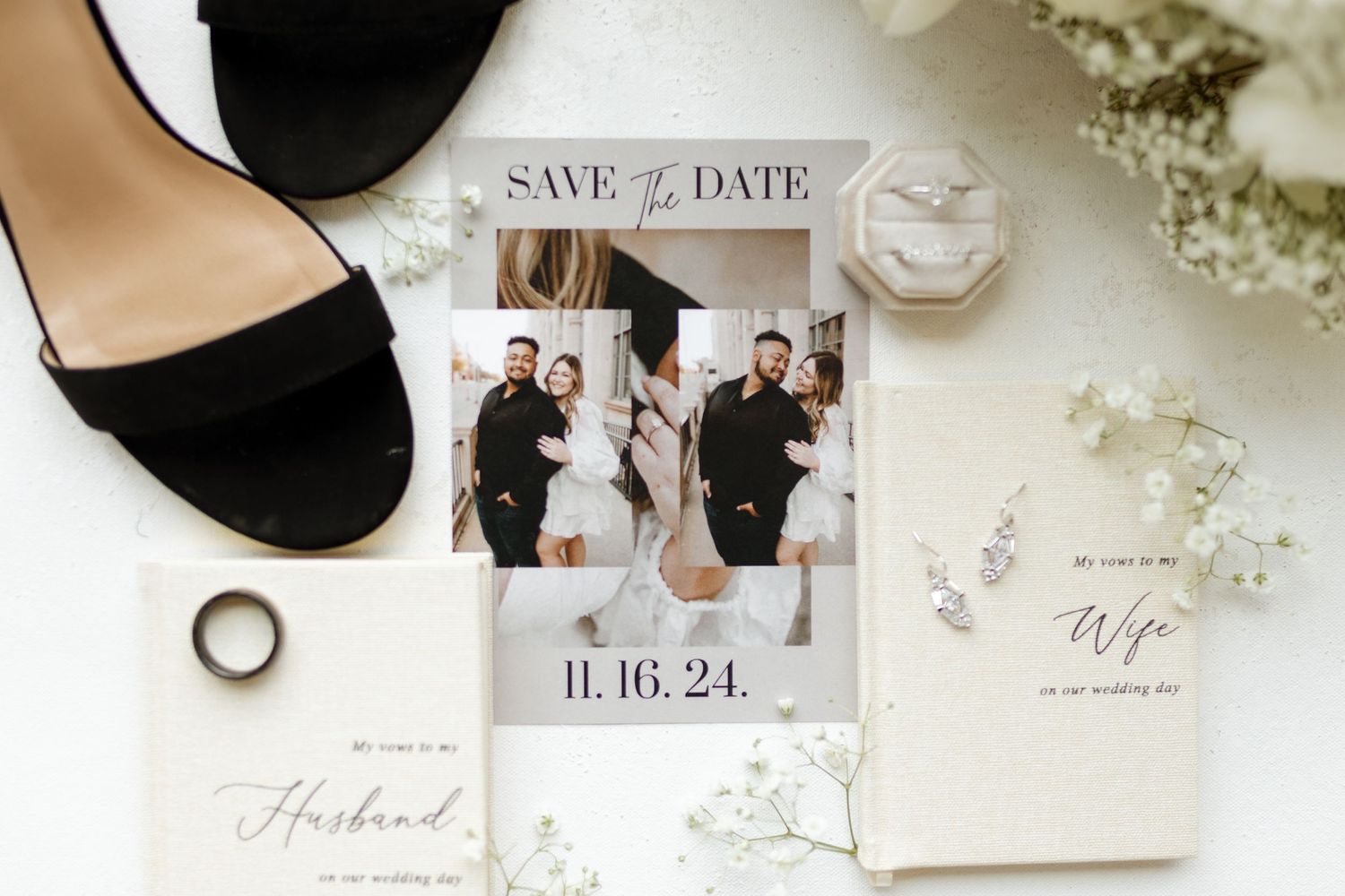 Wedding details flatlay with black shoes, save the date card, and delicate florals.